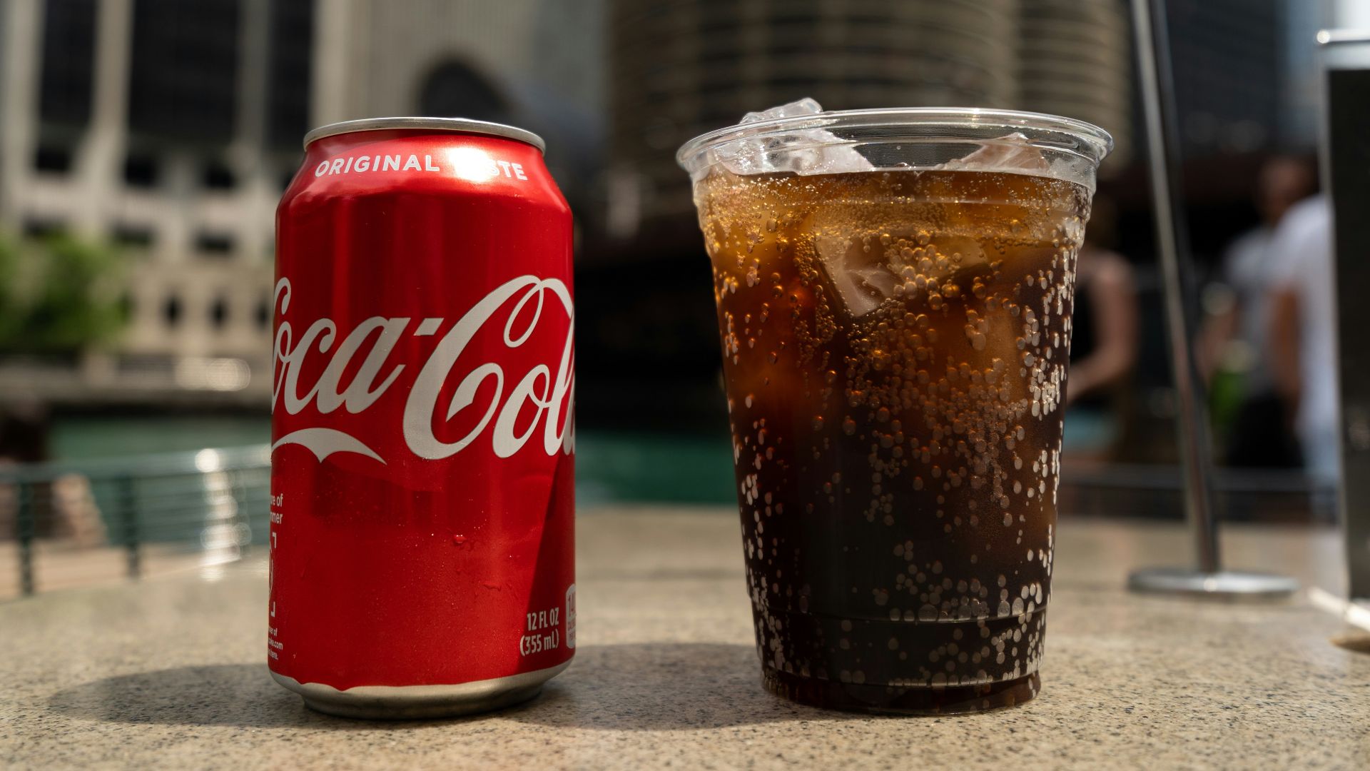 Coca-Cola soda tin can and cup on table close-up photography