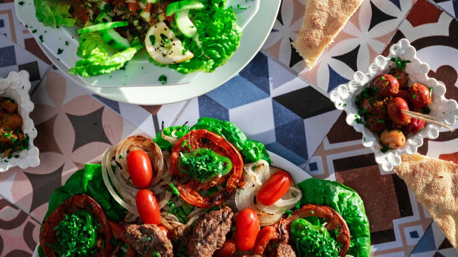 a table topped with plates of food and pizza