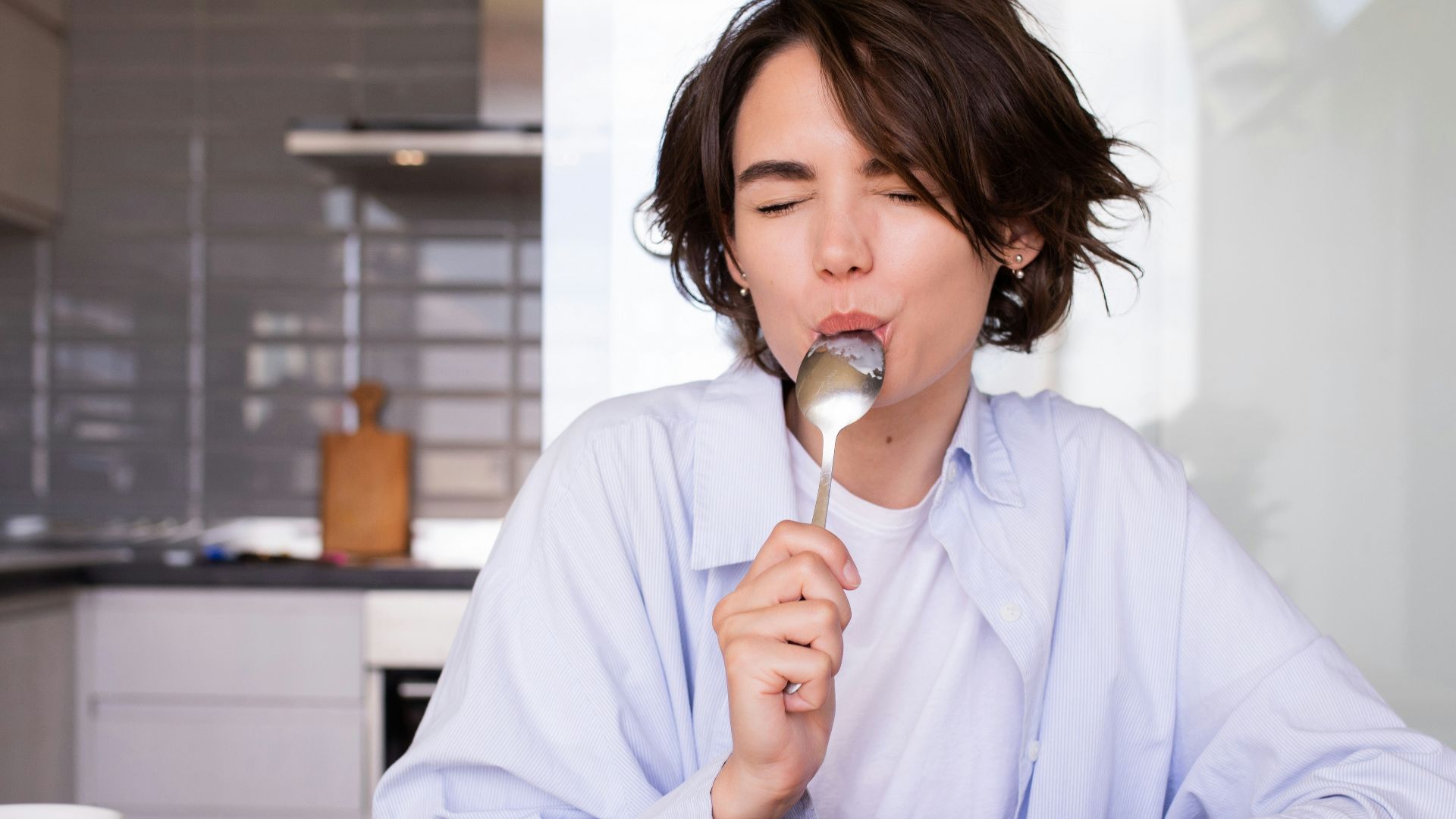a woman eating cereal from a bowl with a spoon