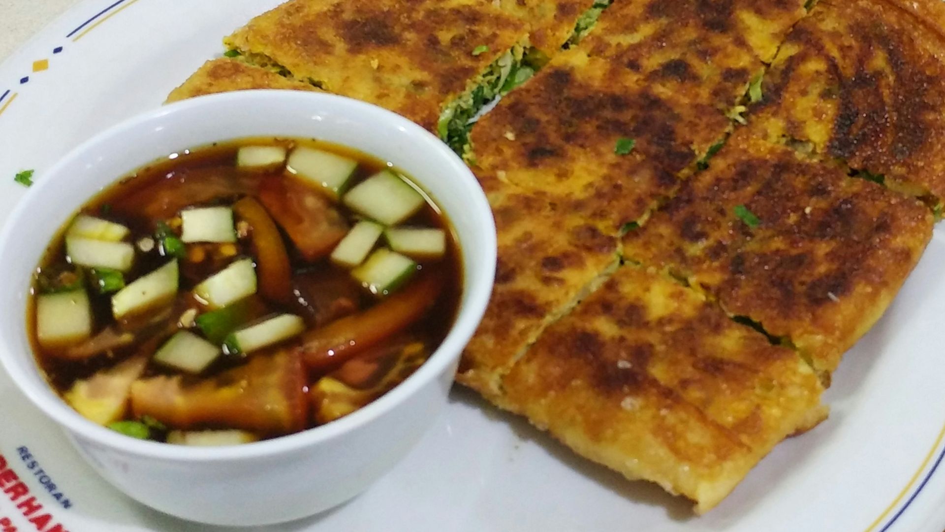 a white plate topped with a sandwich and a bowl of soup