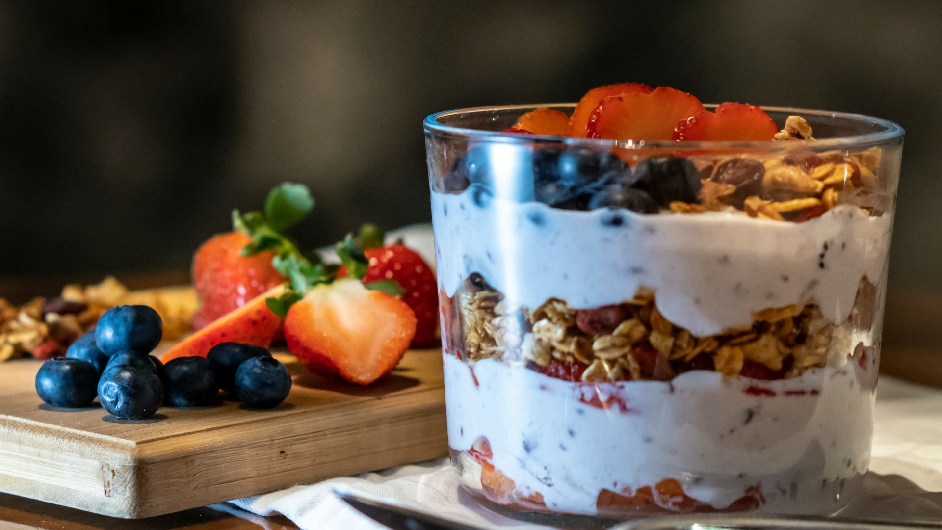 strawberries and cookies with cream filled dessert in glass cup