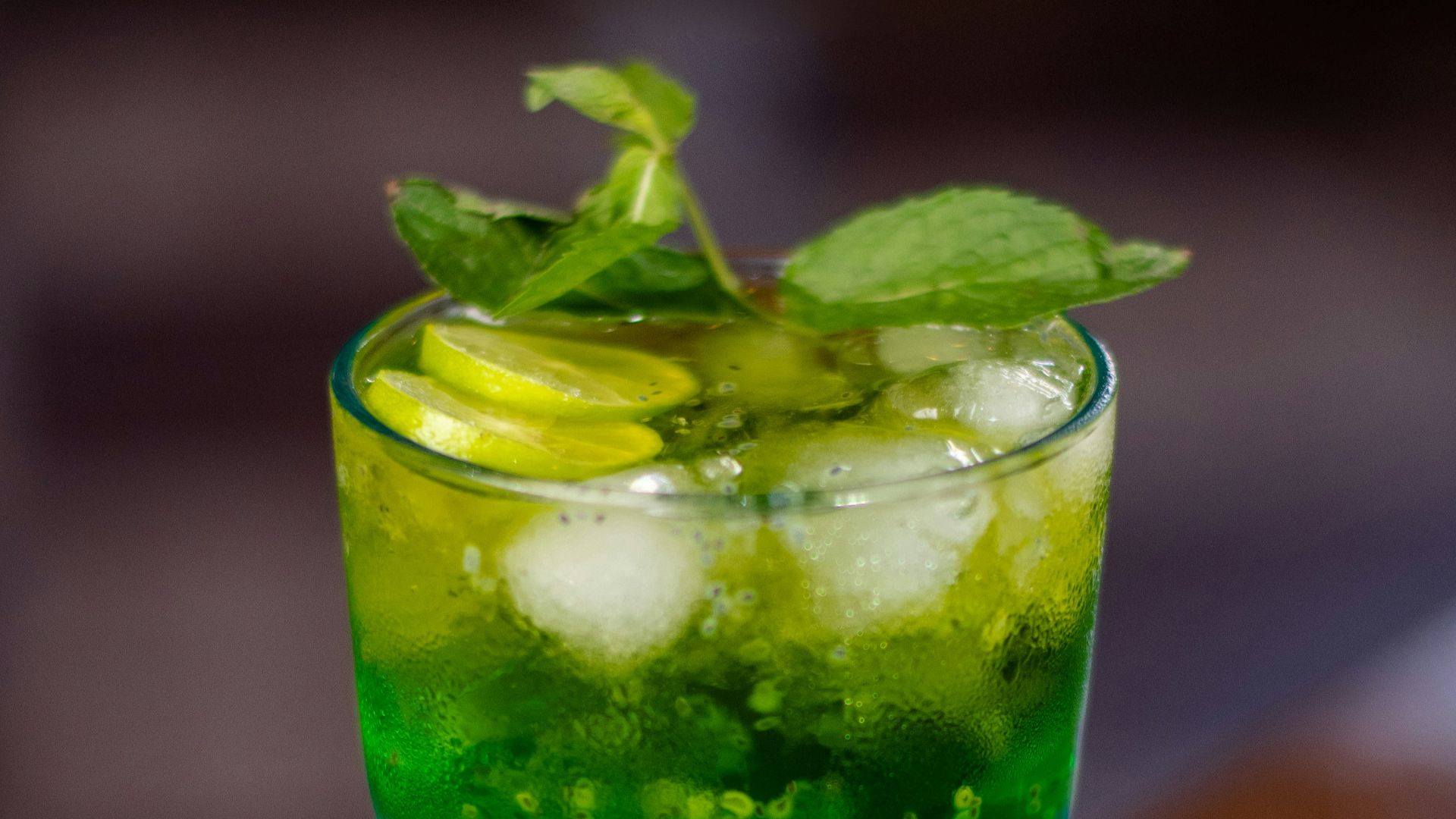 a tall glass filled with green and blue liquid