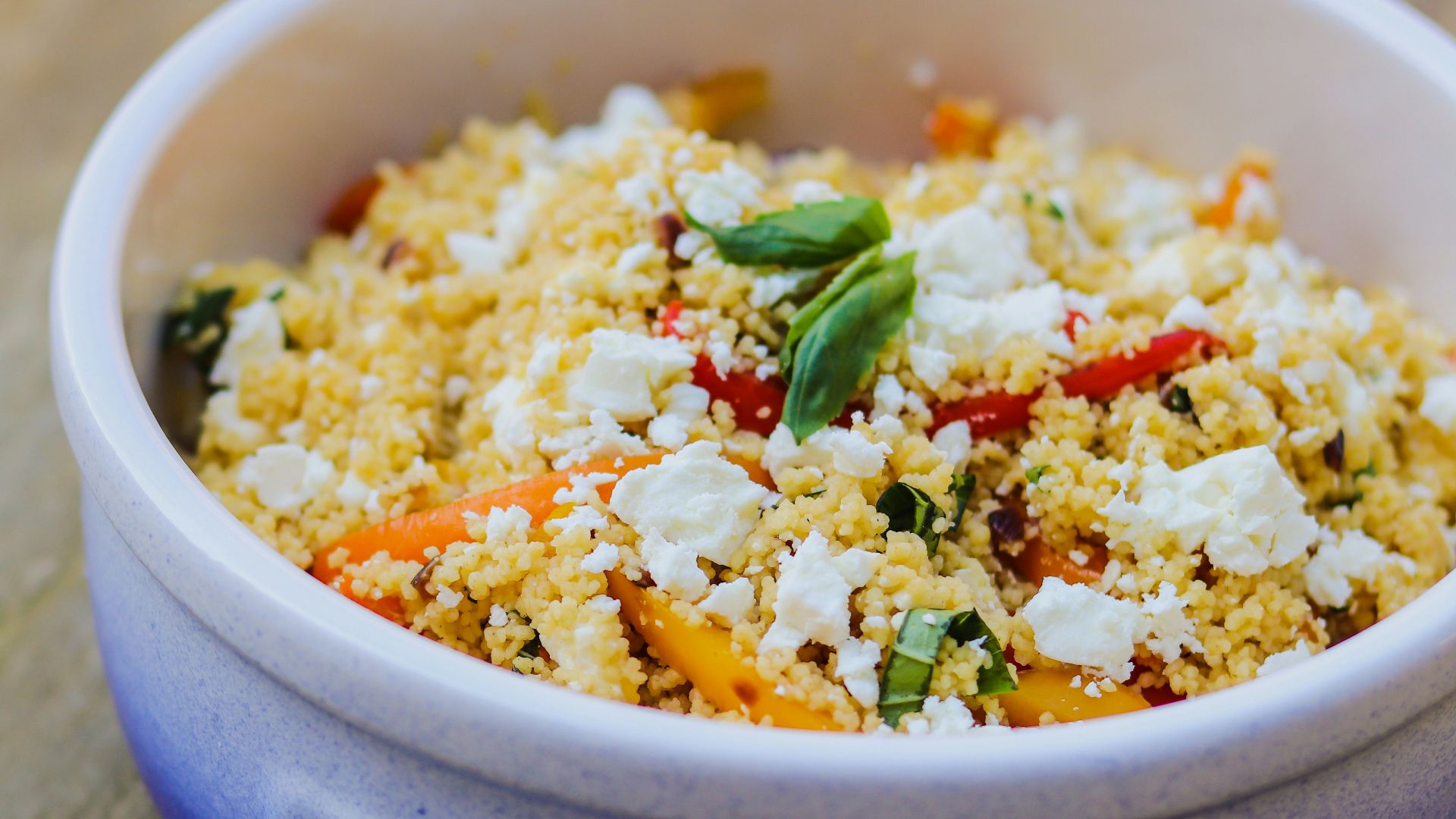 a blue bowl filled with food on top of a wooden table