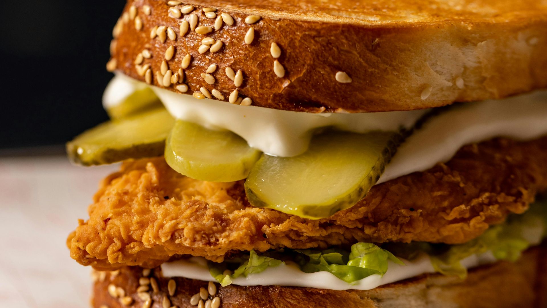 a chicken sandwich with pickles and mayonnaise