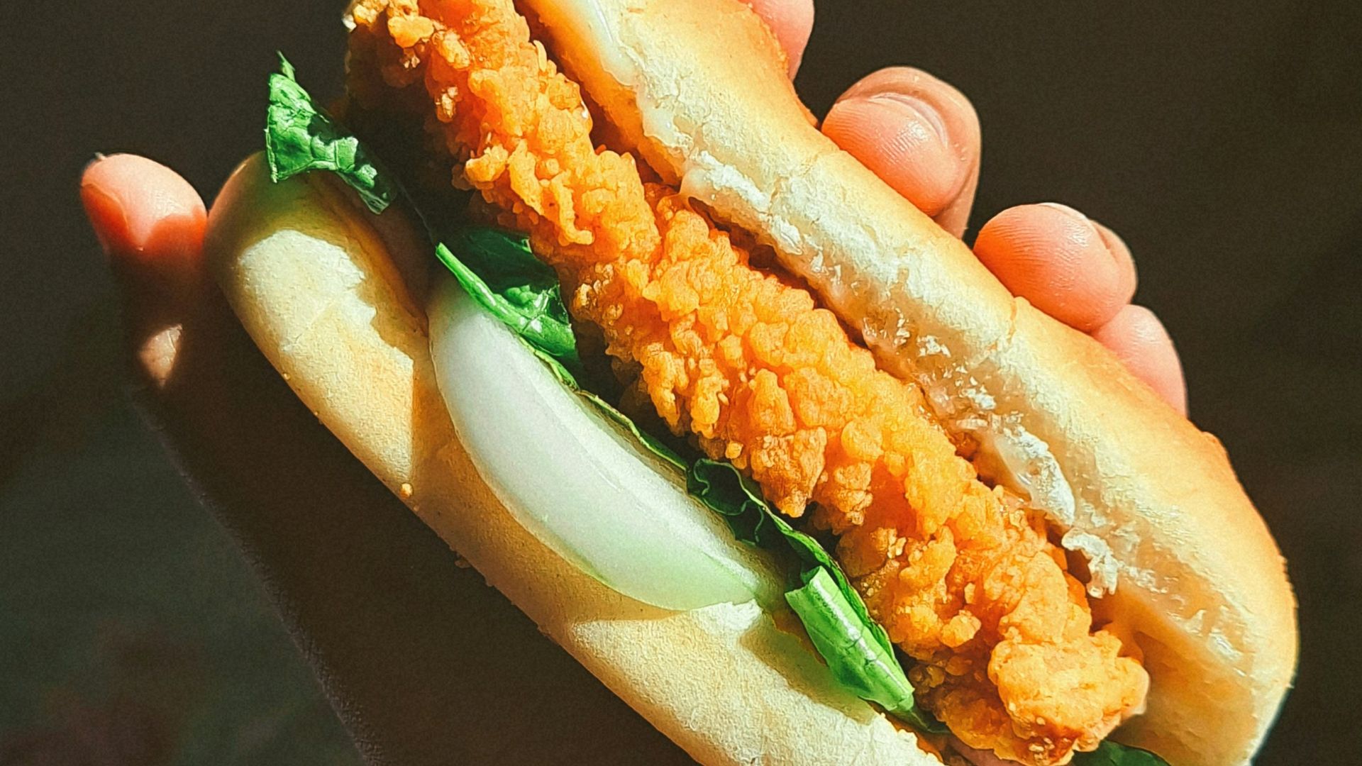 a person holding a sandwich in their hand