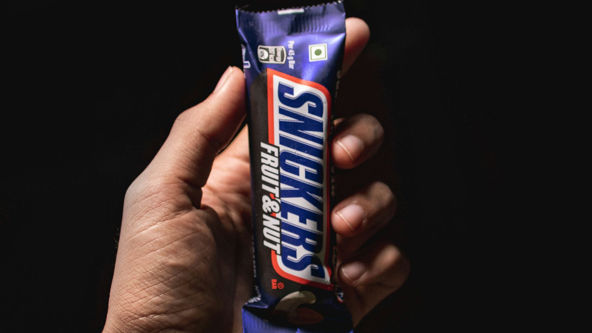 person holding blue and white labeled pack