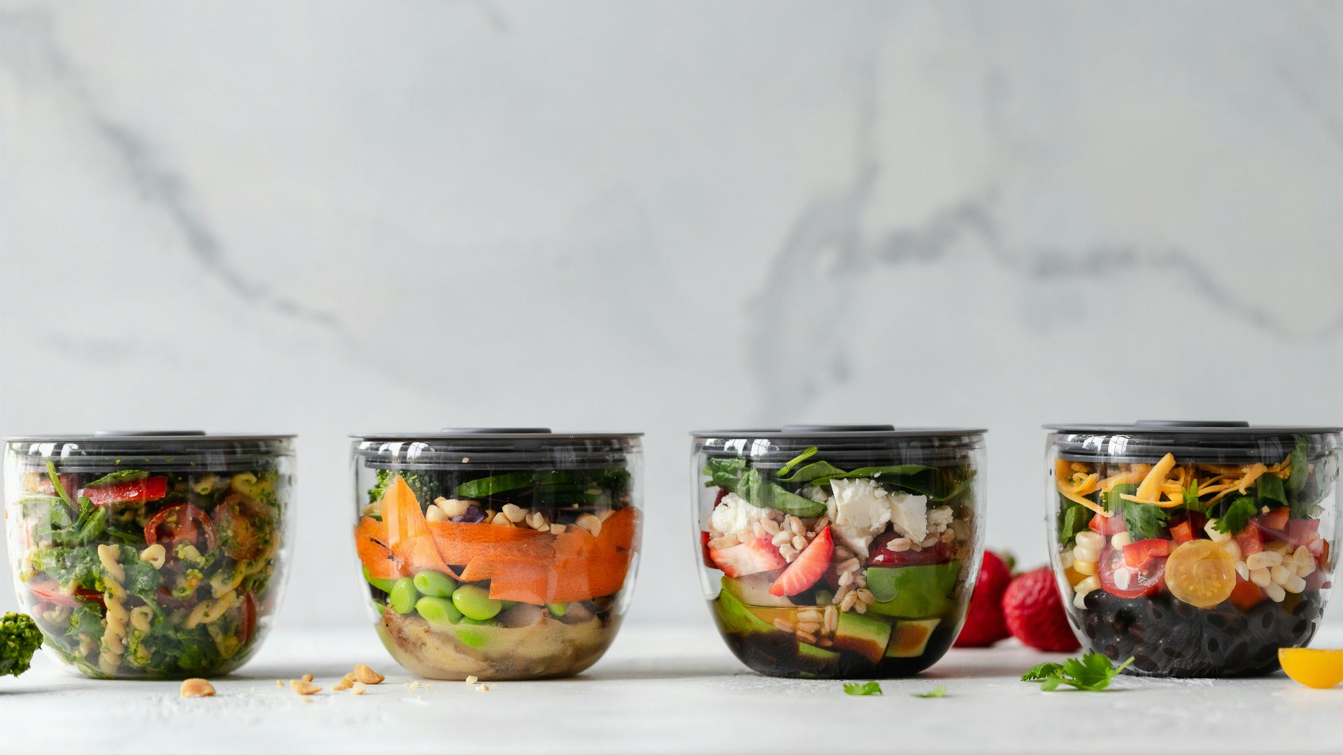 four clear plastic bowls with vegetables