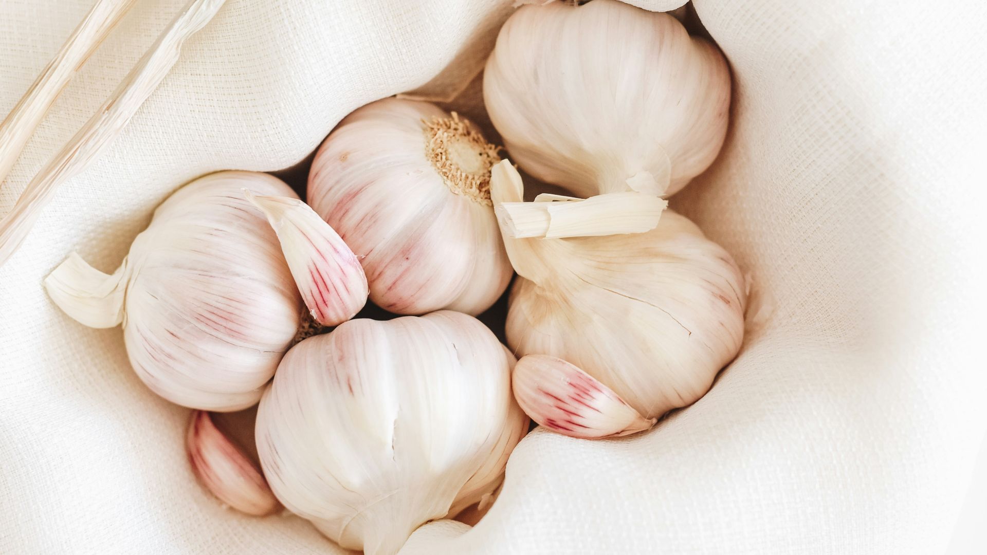 five garlic on white textile