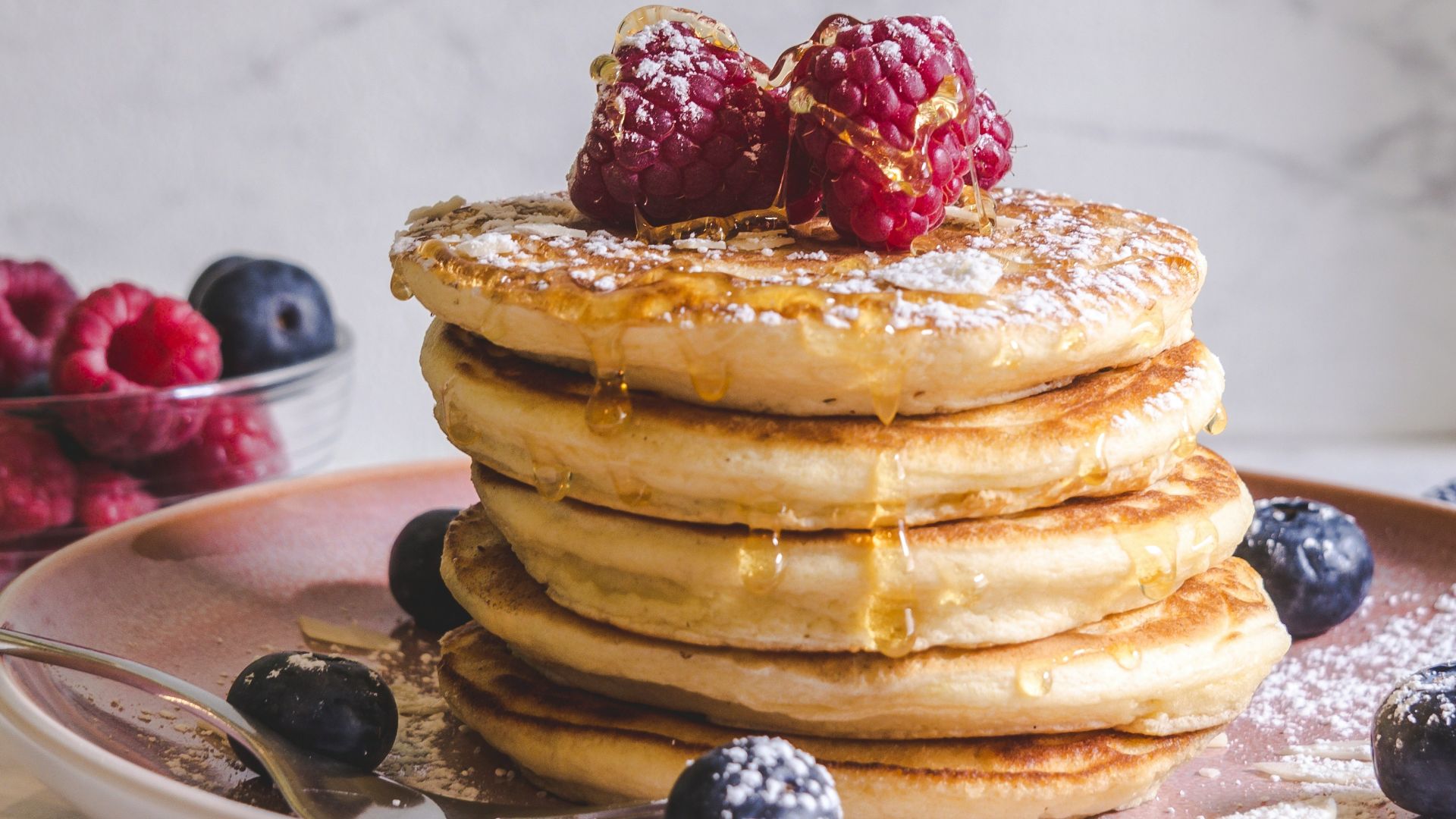 pancakes with berries on white ceramic plate