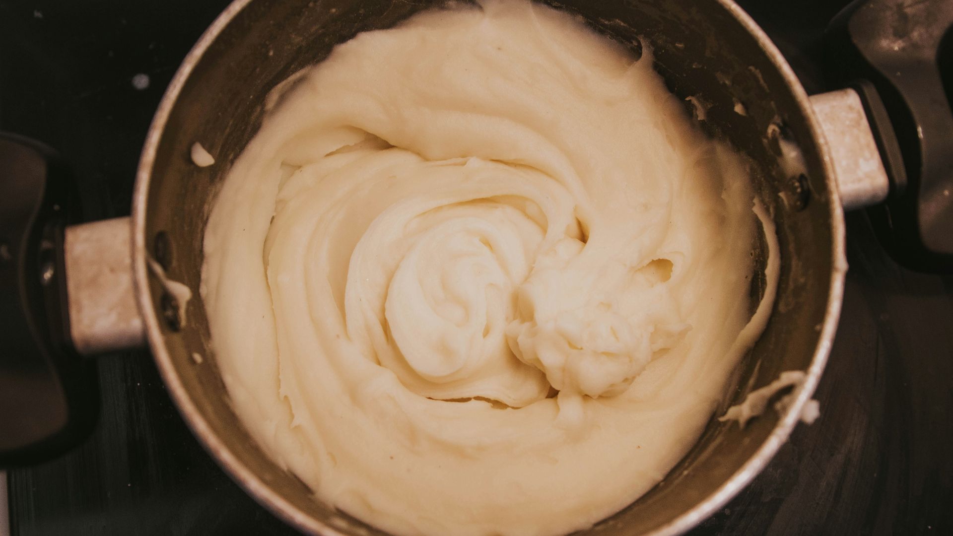 a pot of cream sitting on top of a stove