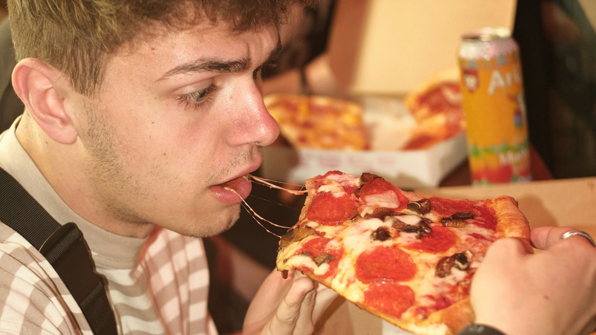 a man eating a slice of pizza in a restaurant