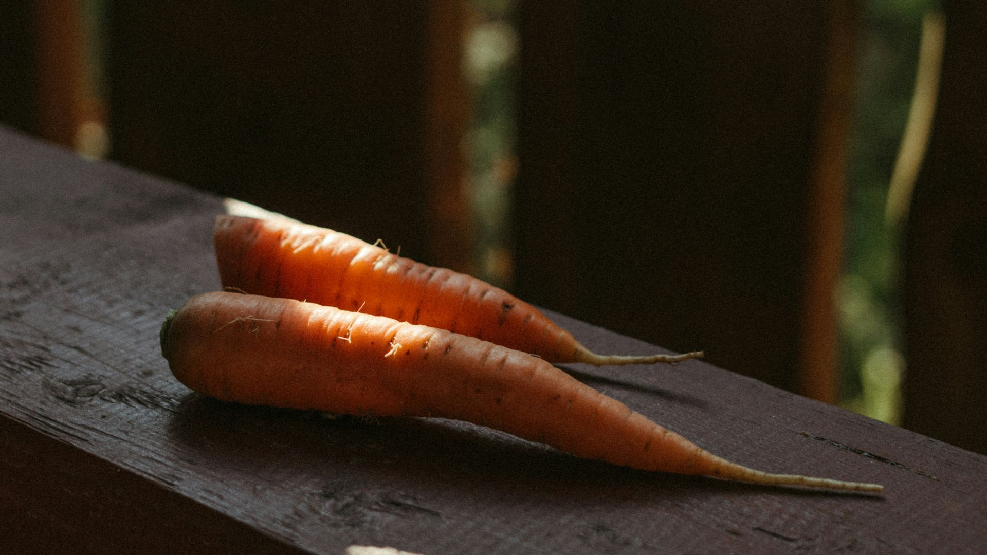 A couple of carrots sitting on top of a wooden table