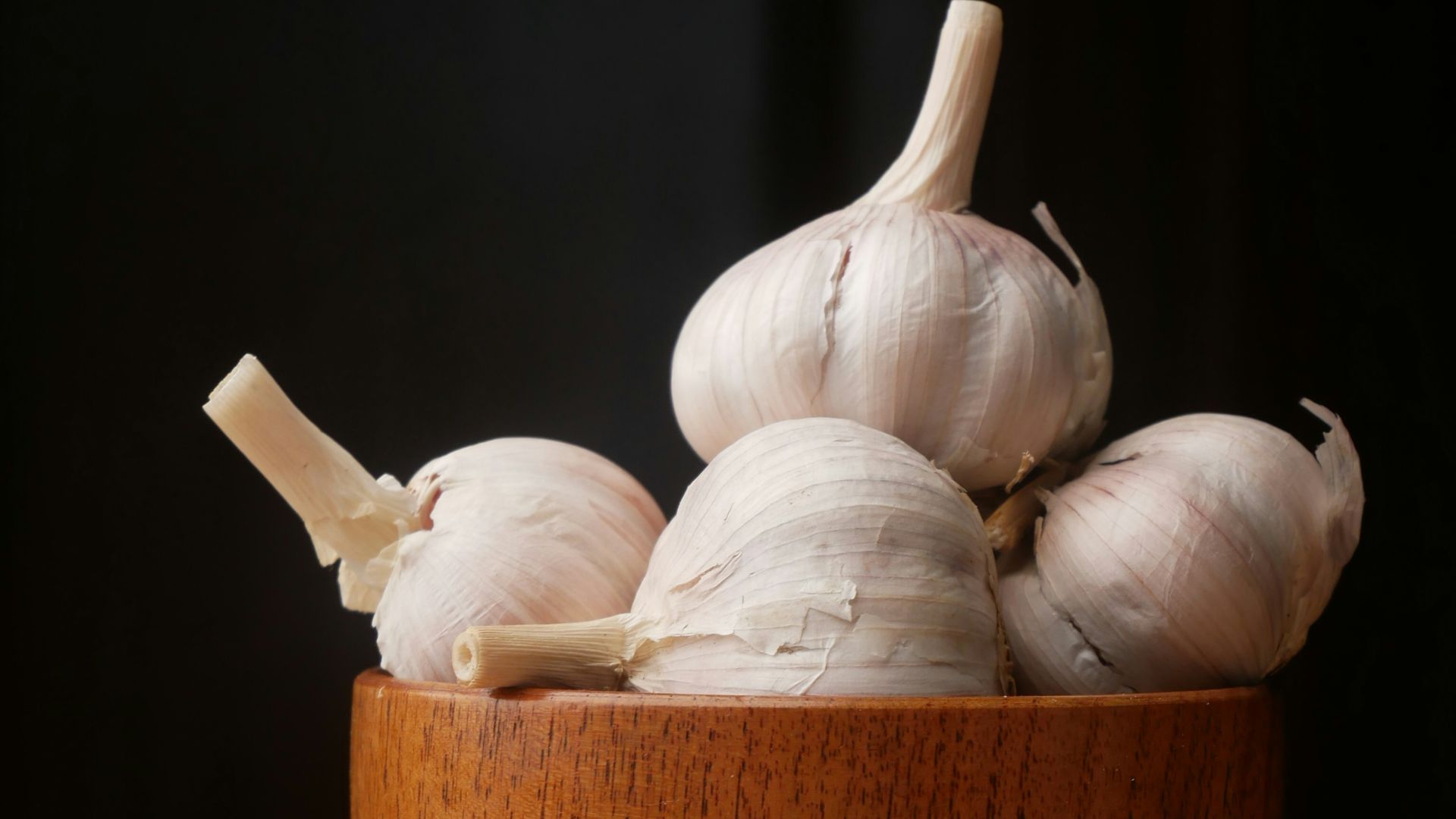 garlic on brown wooden bowl
