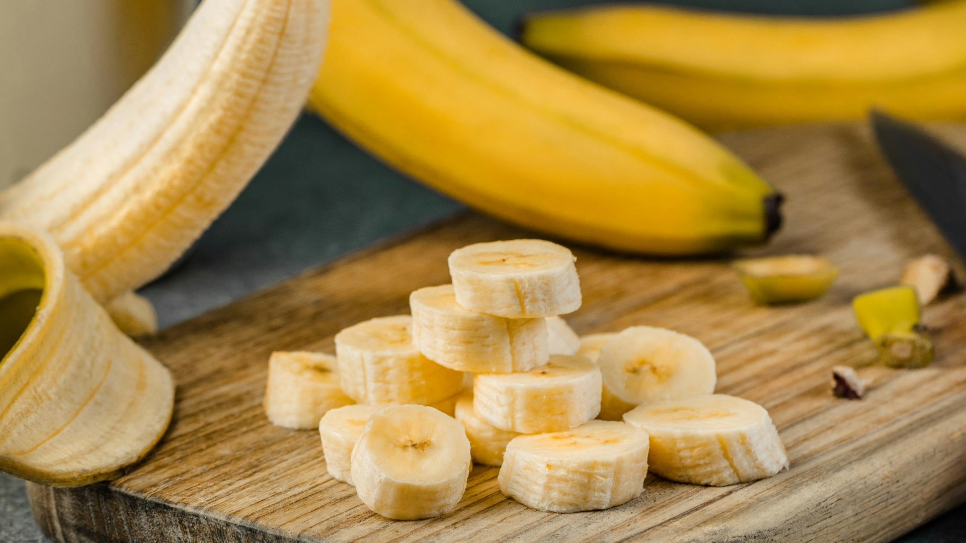 yellow banana fruit on brown wooden chopping board
