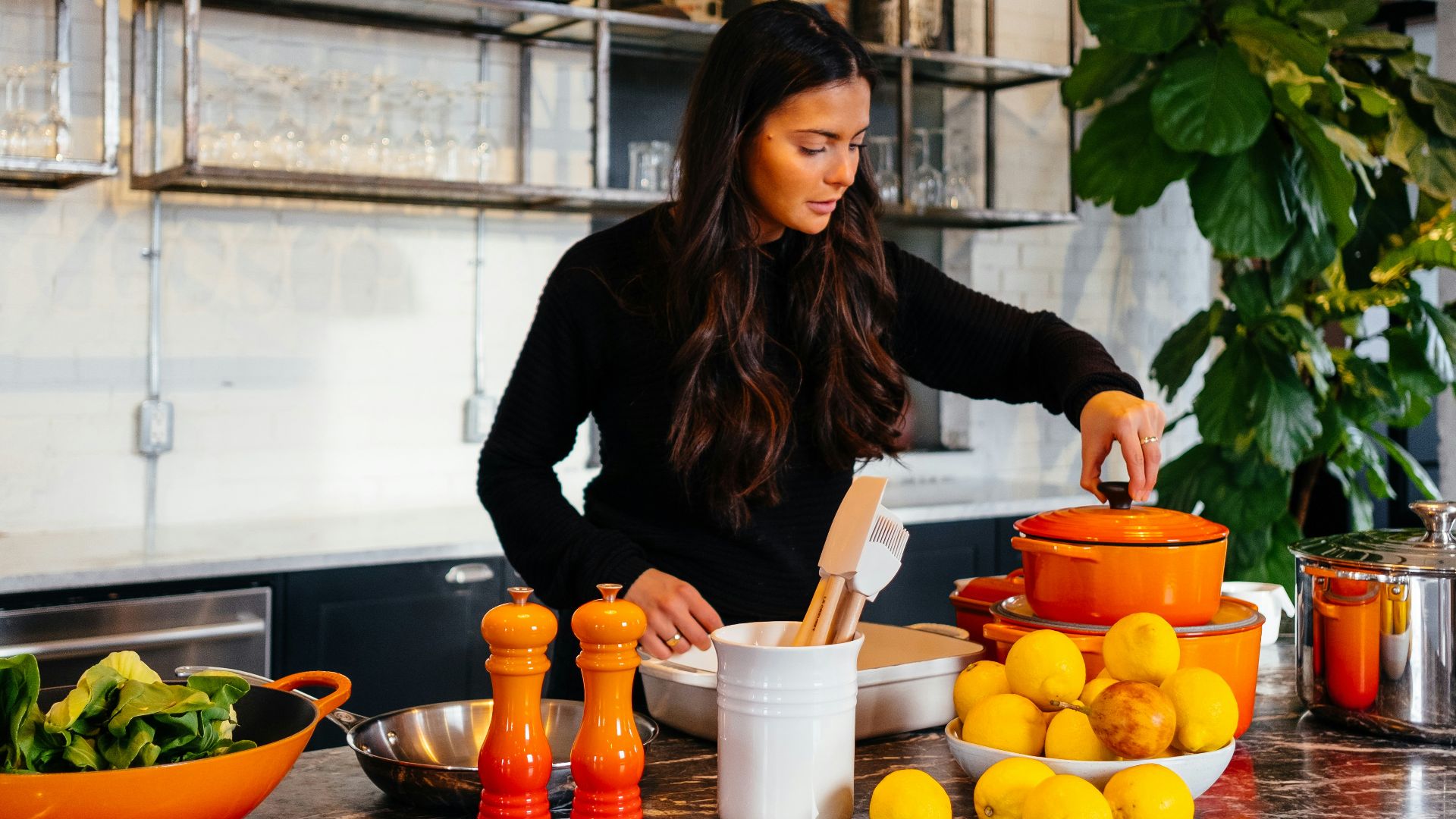 woman standing in front of fruits holding pot's lid