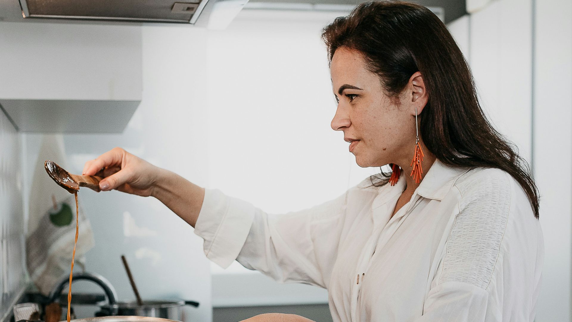 woman in white dress shirt holding stainless steel cooking pot