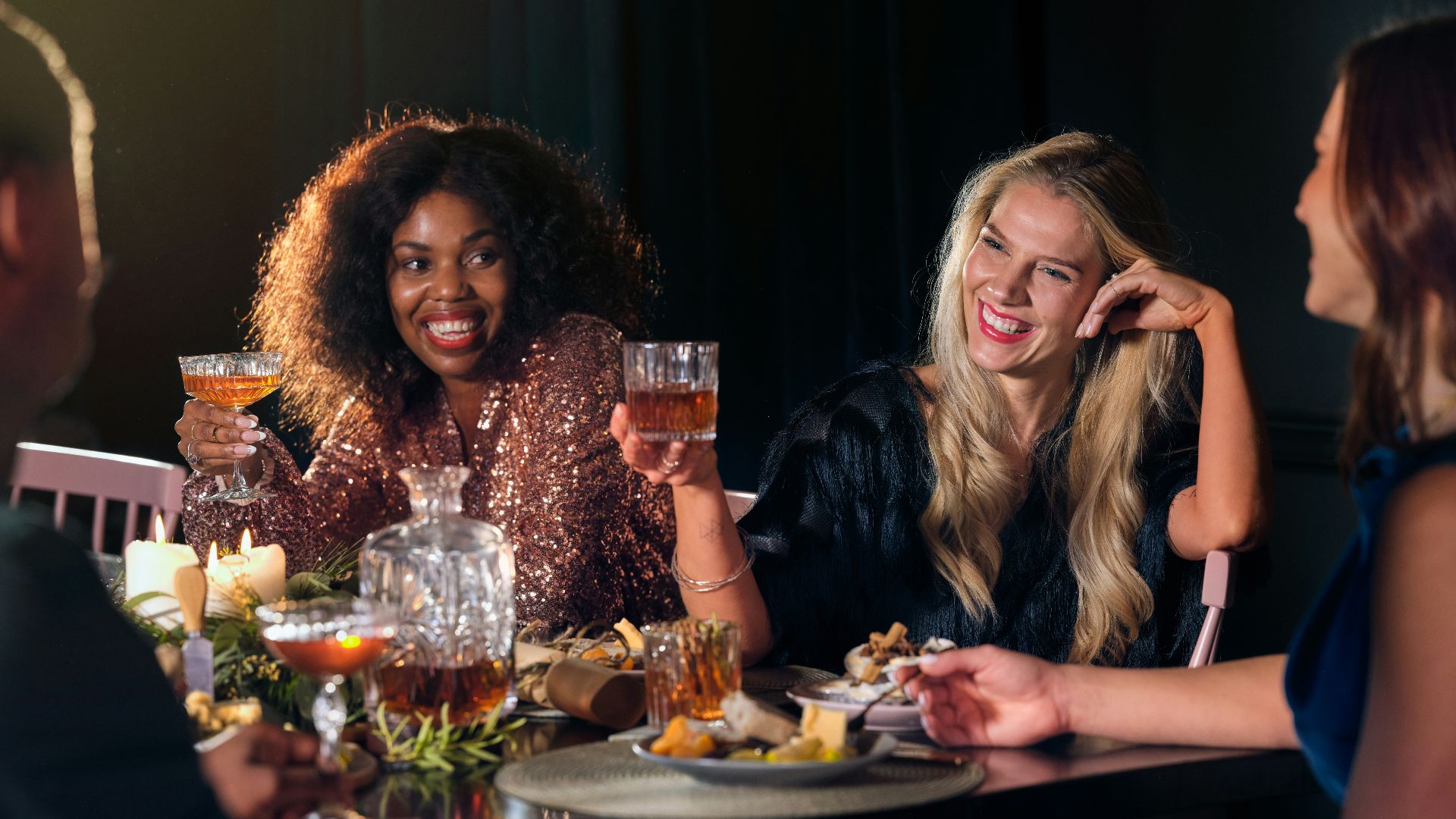 a group of people sitting around a table with food and drinks