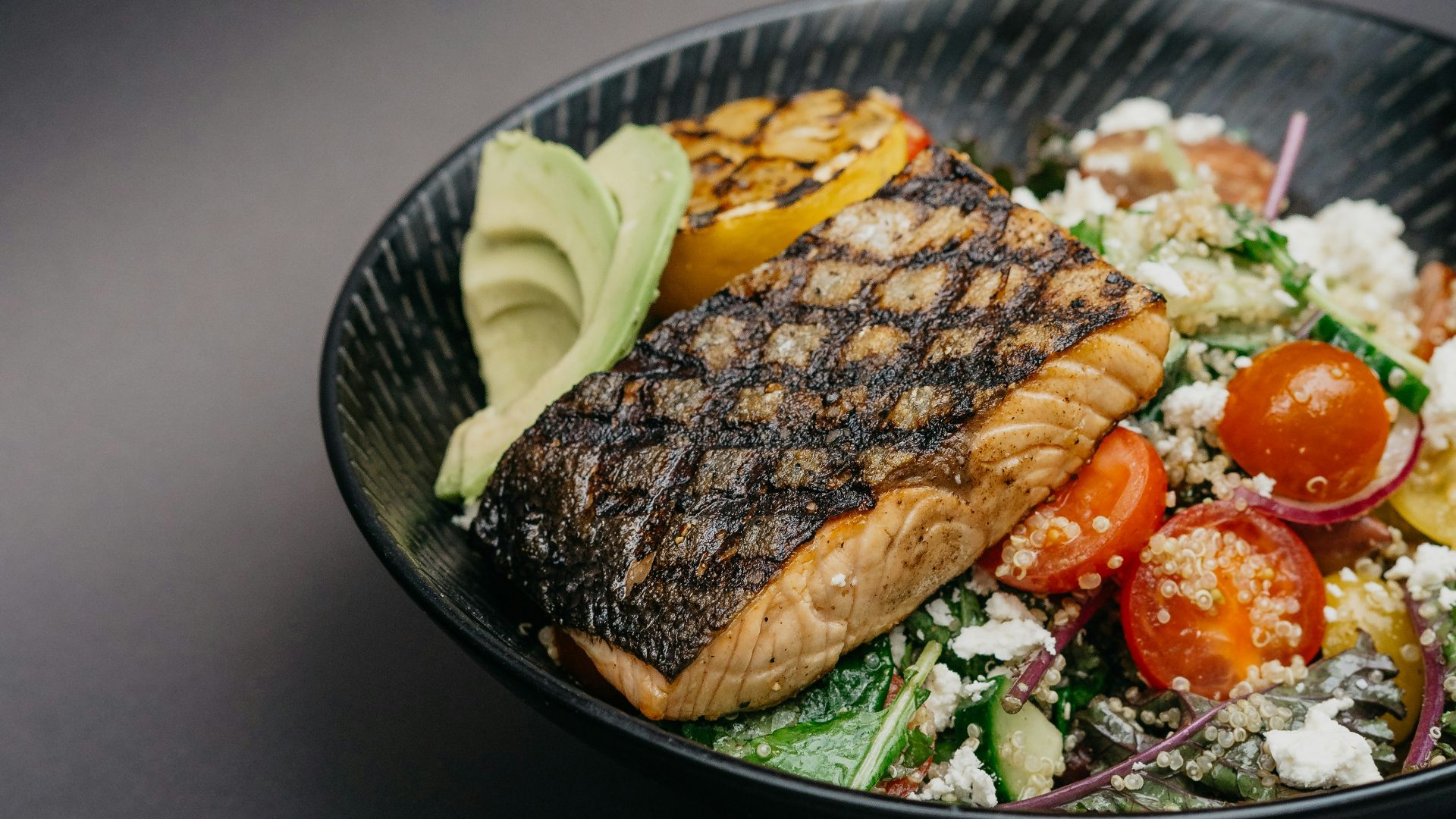 grilled meat with green vegetable on black ceramic plate