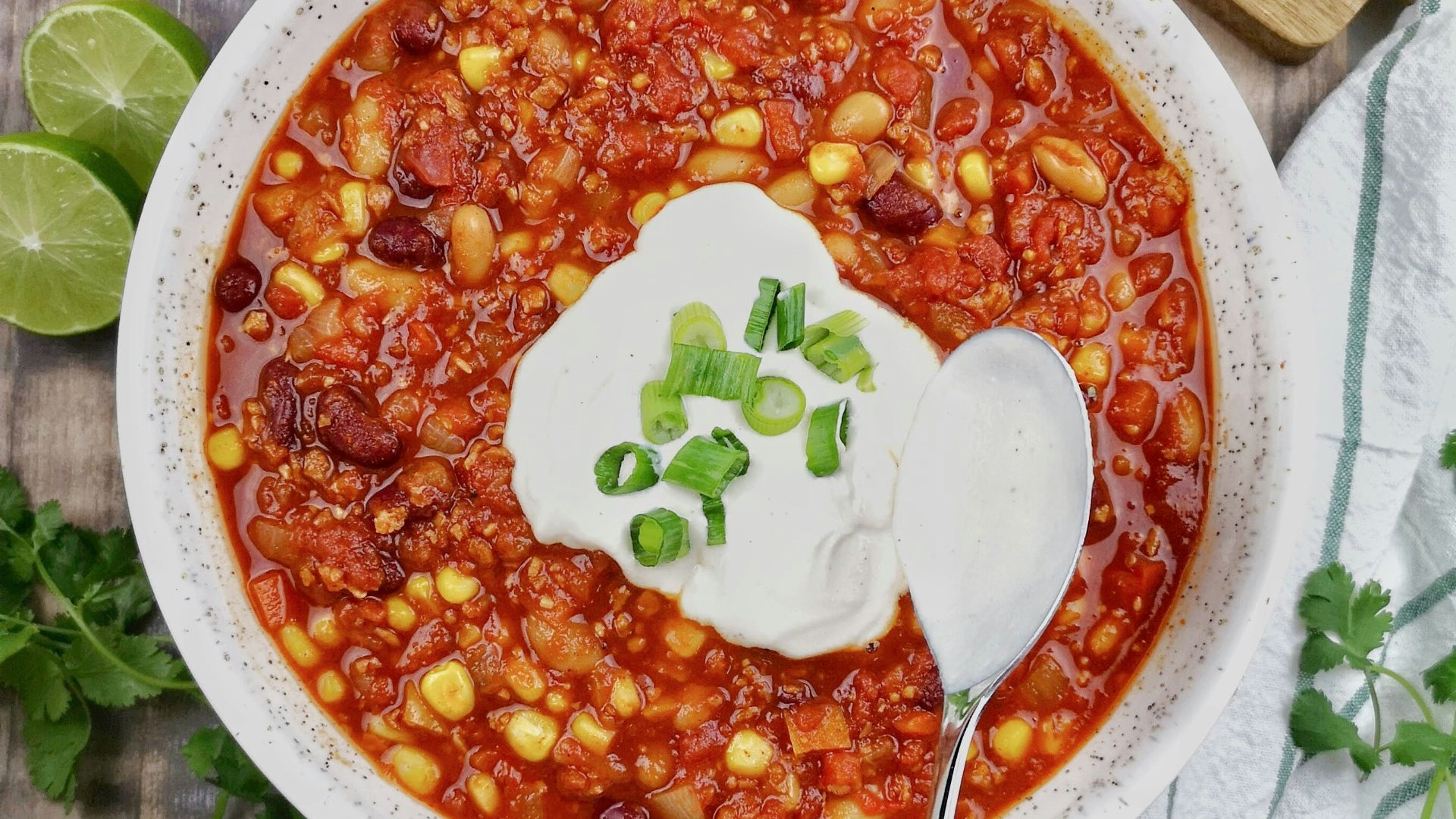a bowl of chili with sour cream on top