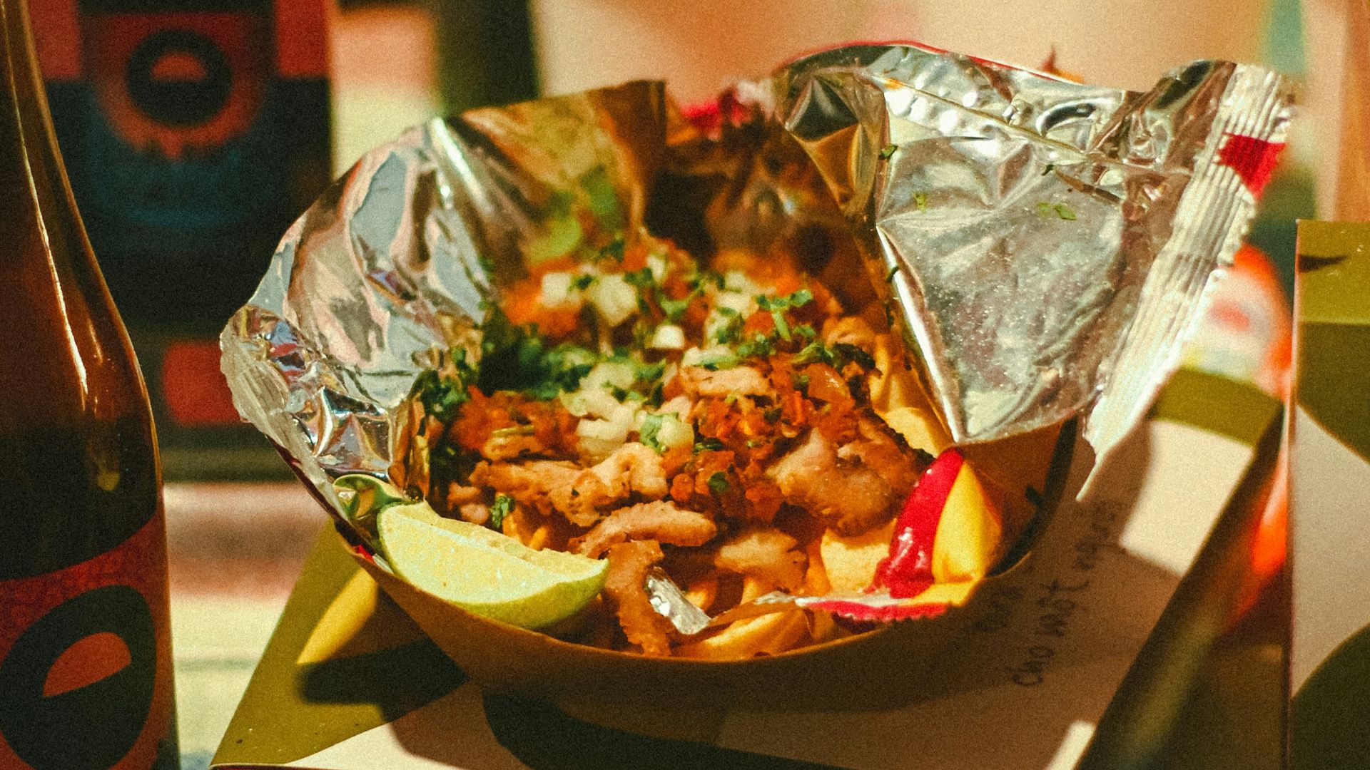 a plate of food sitting on top of a table next to a bottle of beer