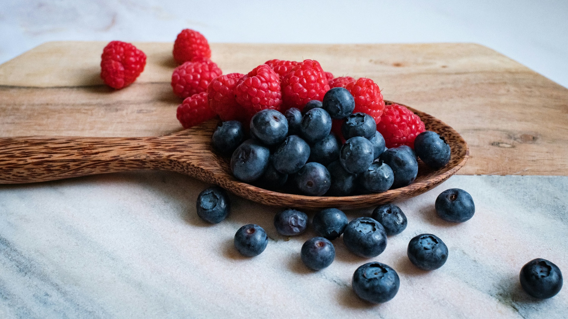 black berries on brown wooden spoon