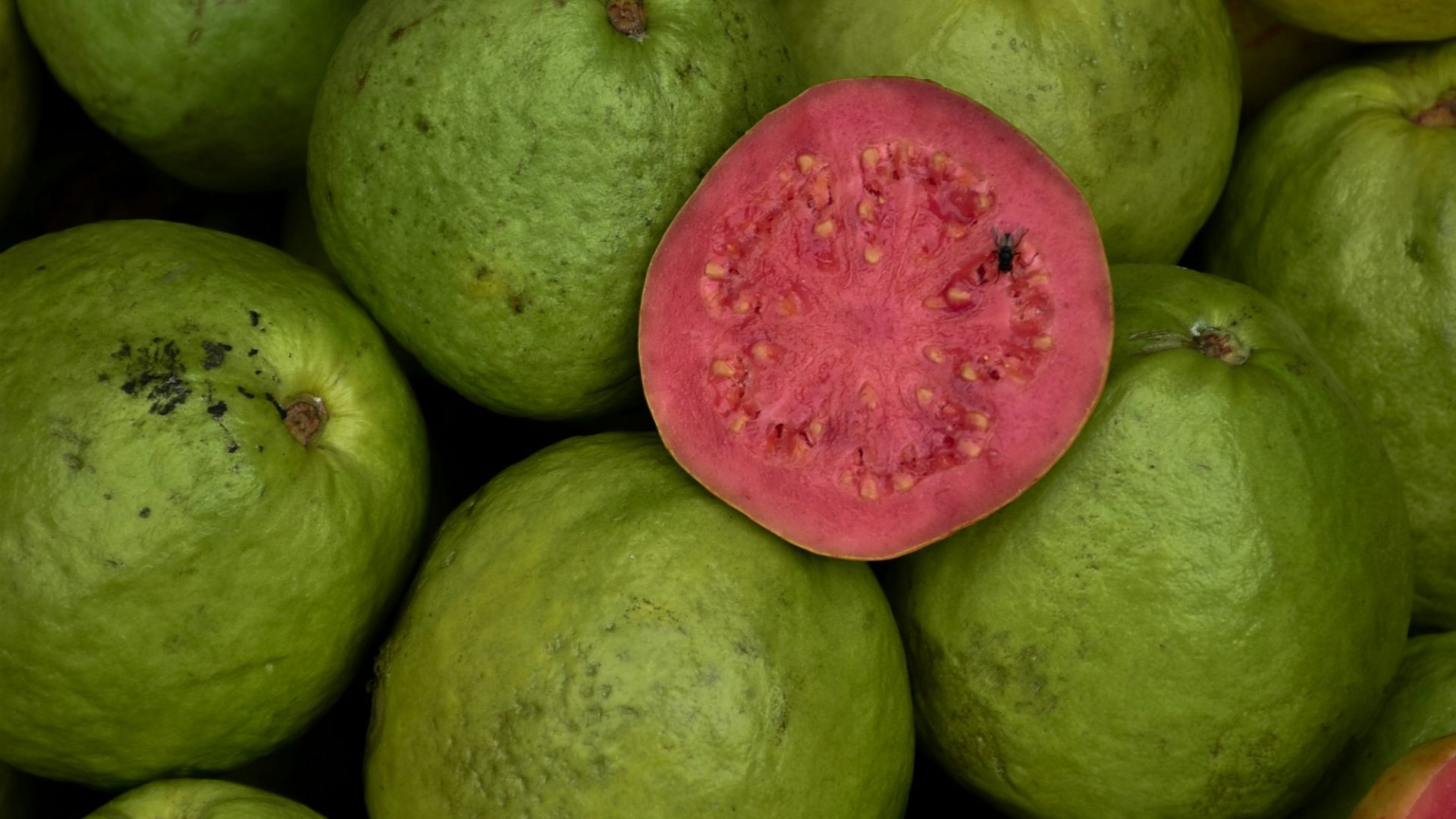 a pile of green and red fruit sitting on top of each other