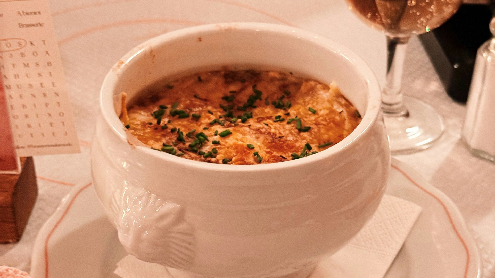 French onion soup in a white bowl with cheese topping