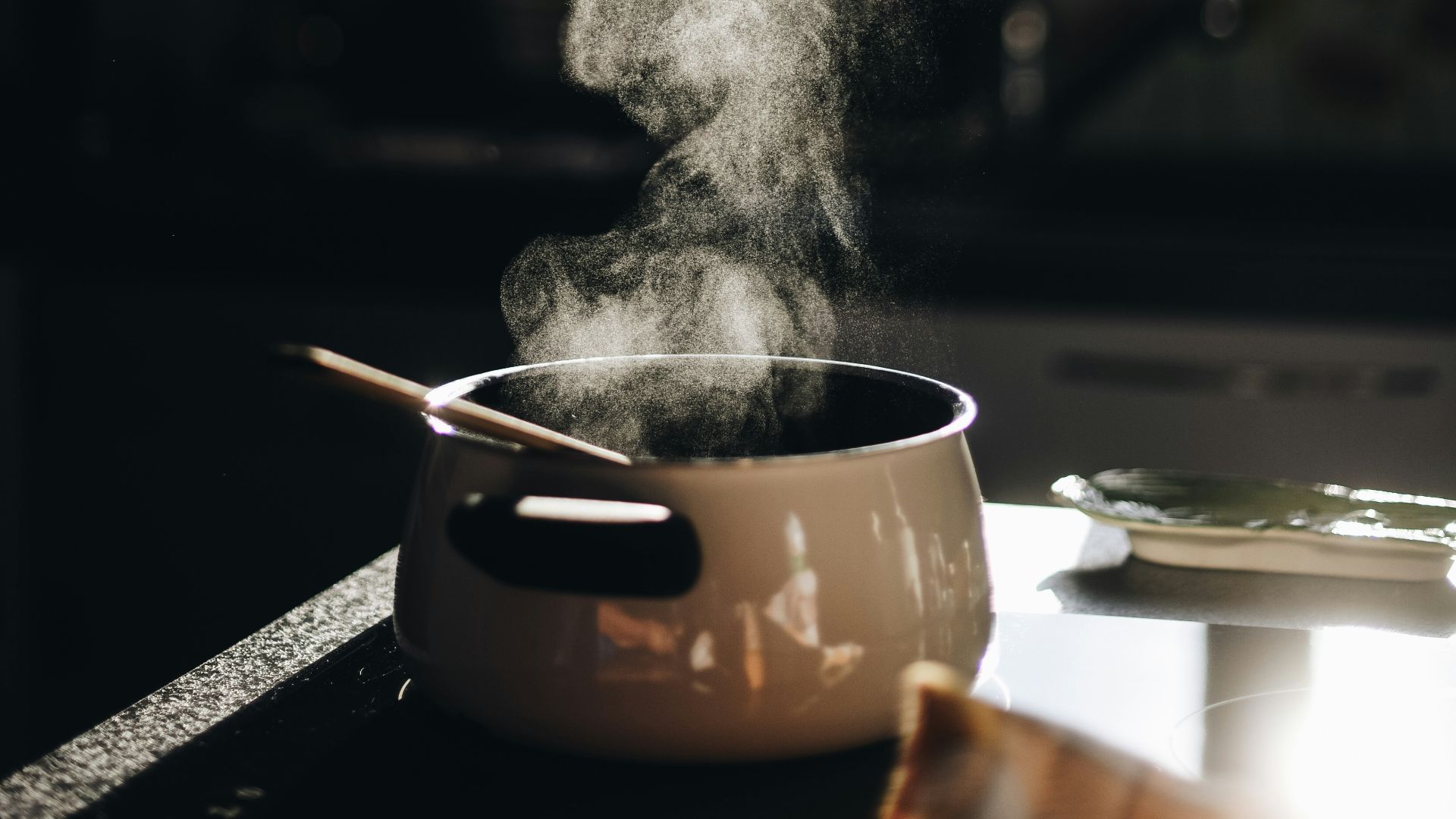 white casserole with gray spoon on black surface