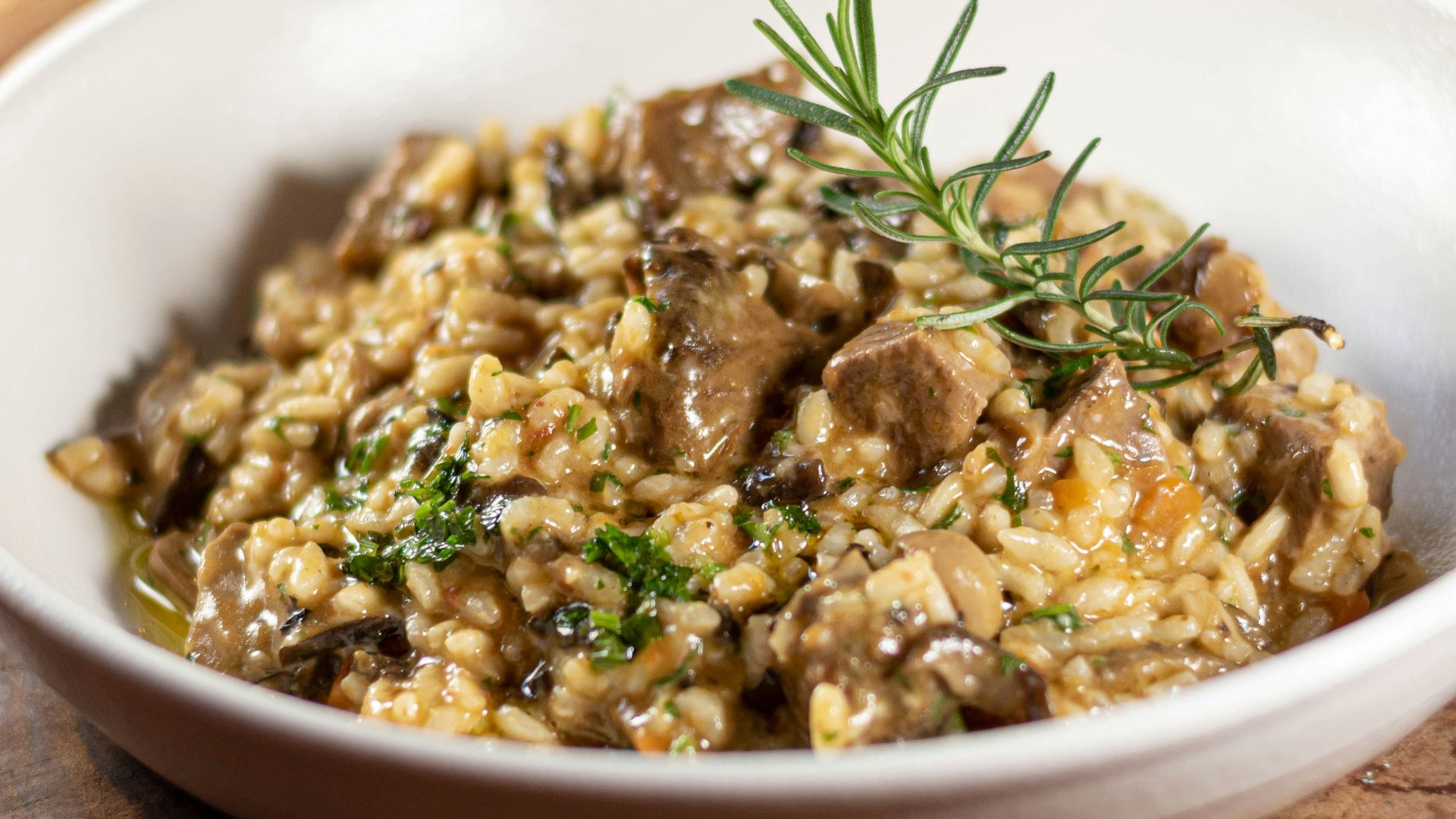 a white bowl filled with food on top of a wooden table