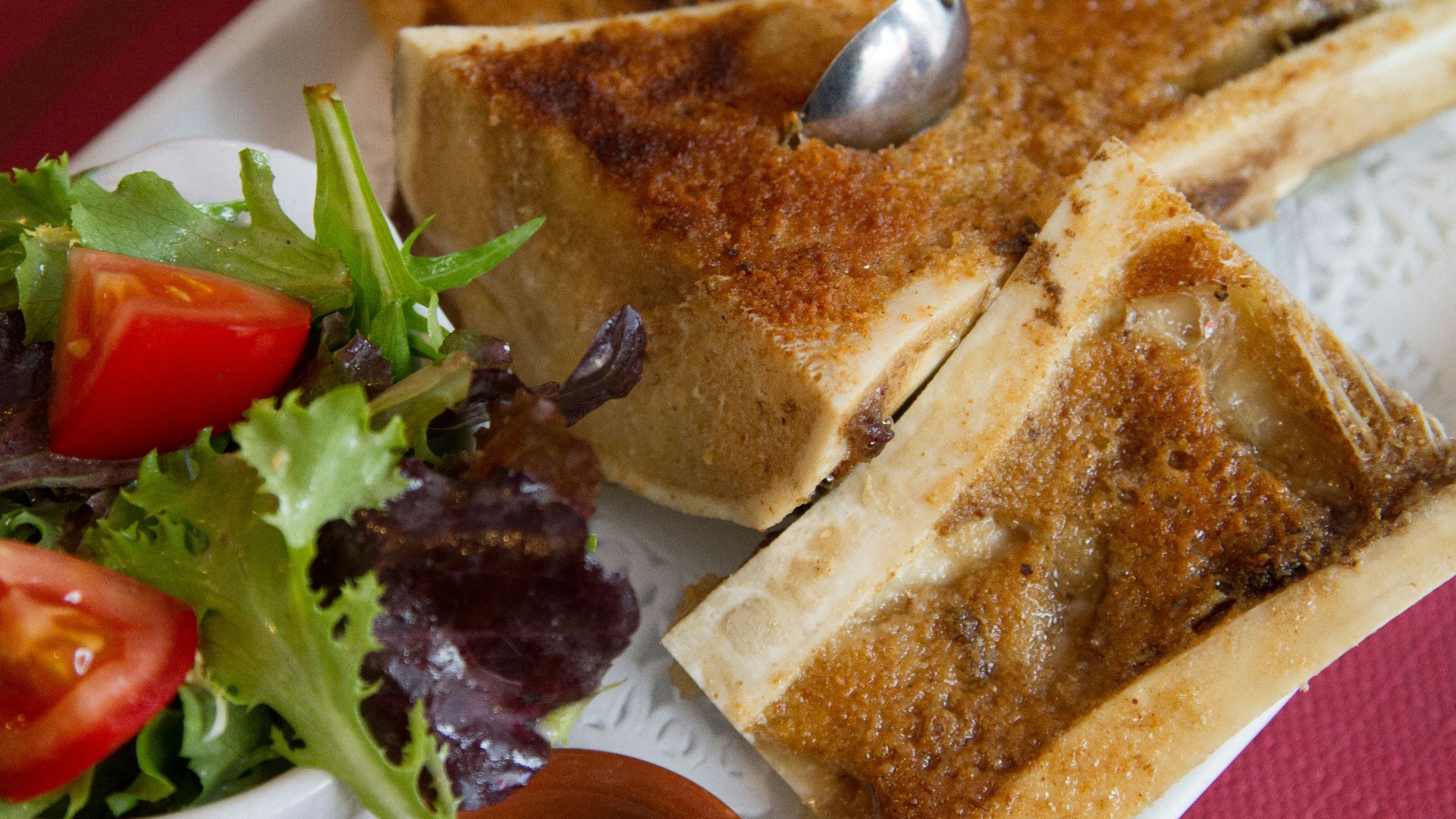 A white plate topped with toasted bread and a salad