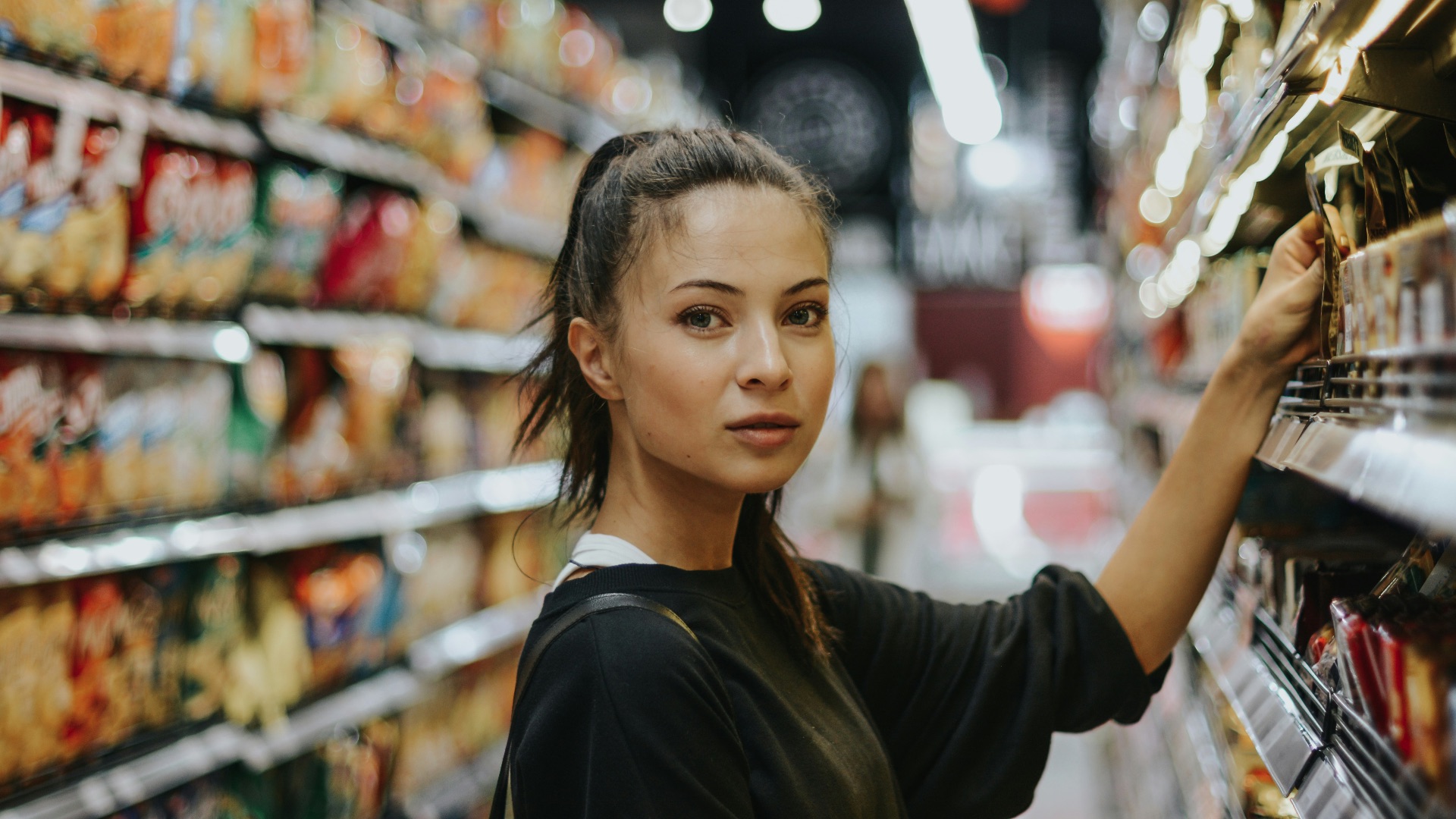 woman selecting packed food on gondola