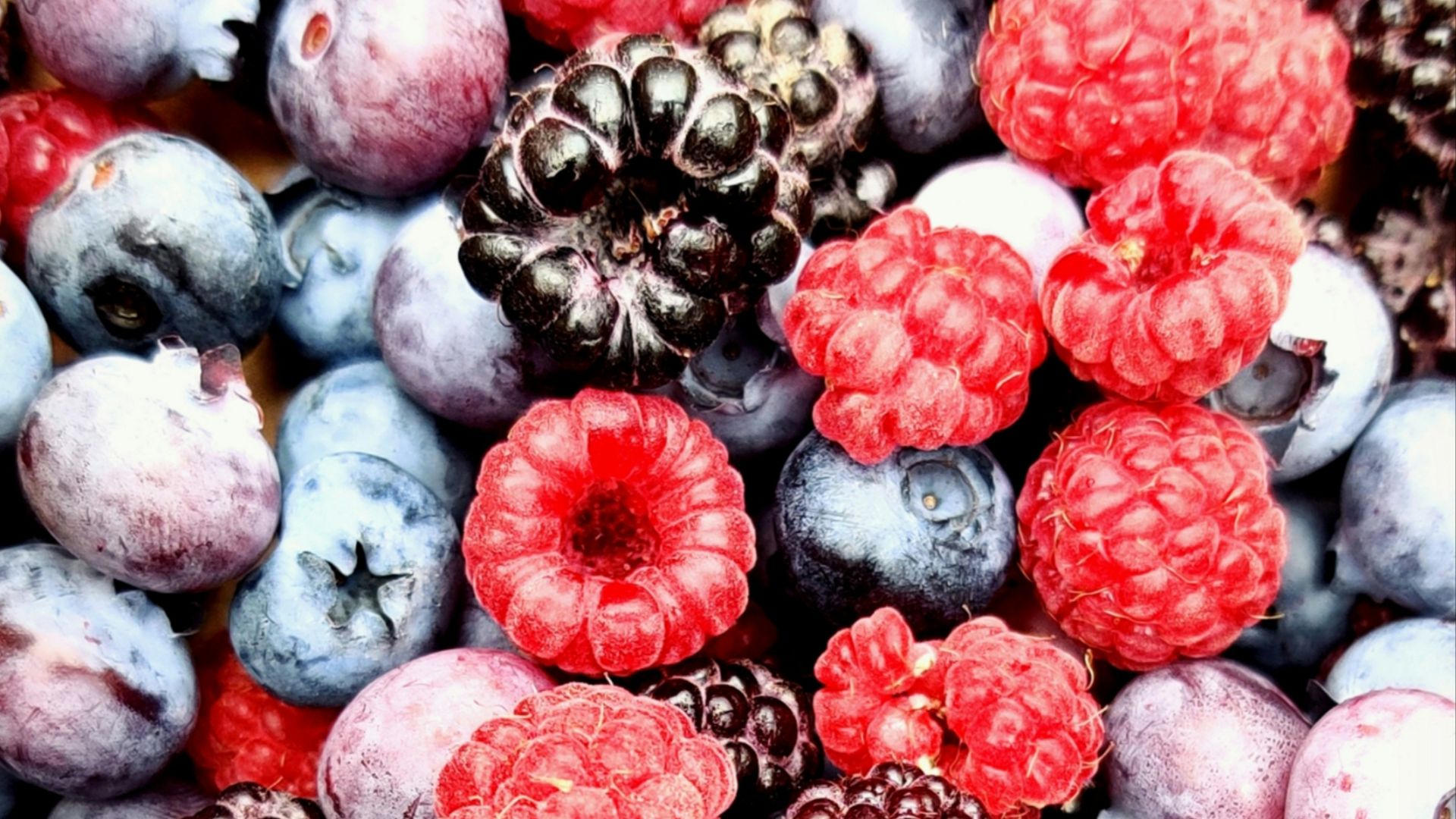 red and black berries on black surface