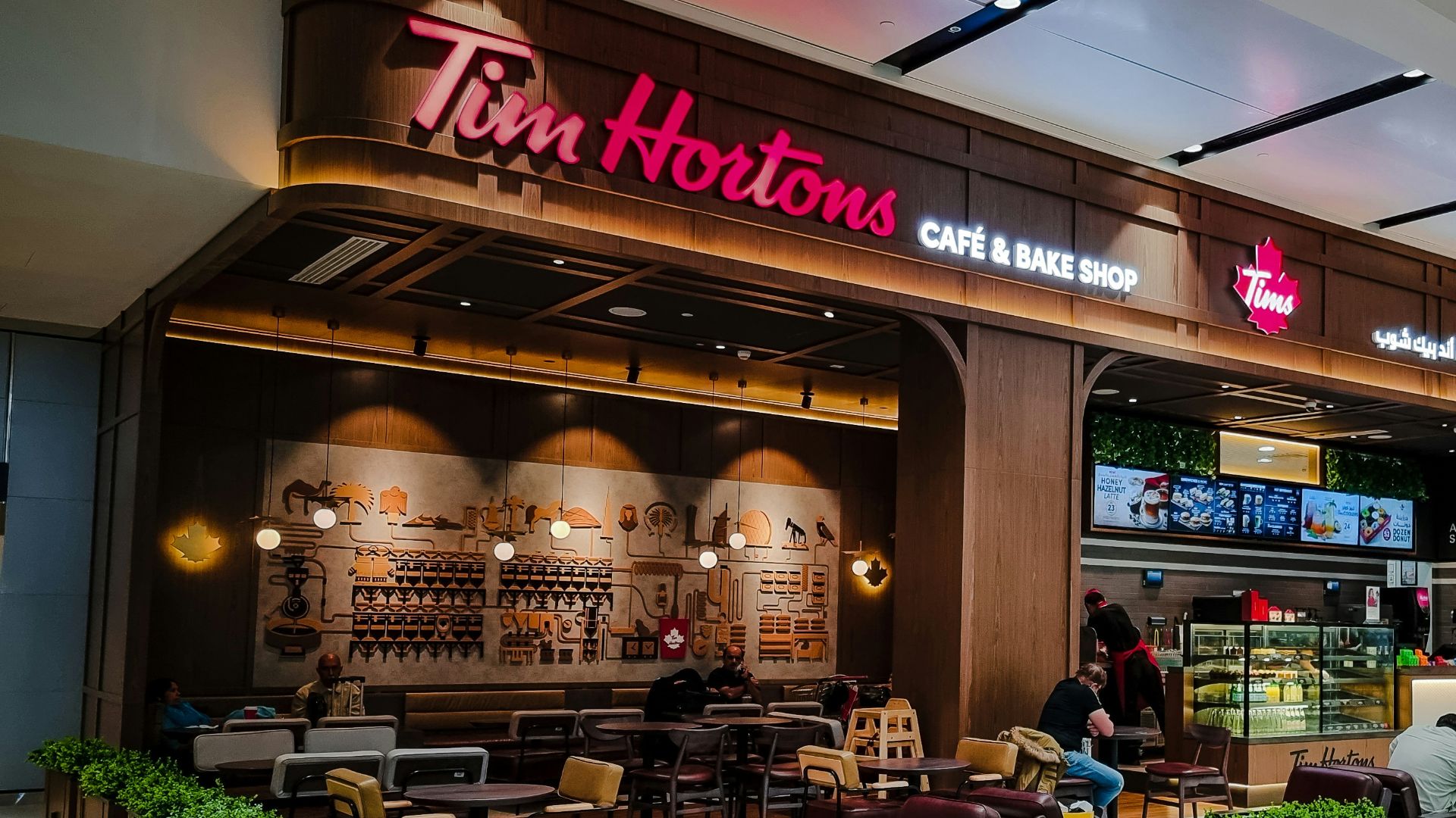 a group of people sitting at tables in front of a restaurant