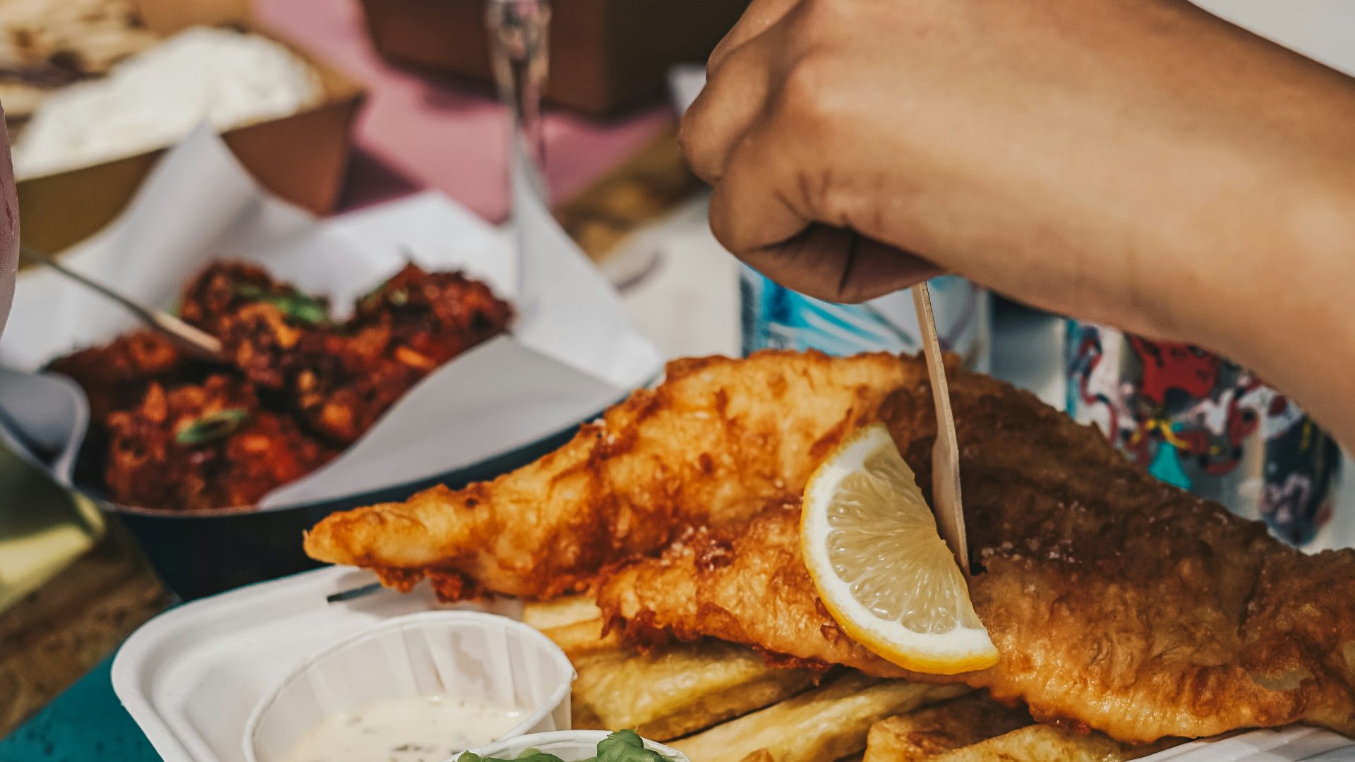 a person cutting a piece of fish with a knife