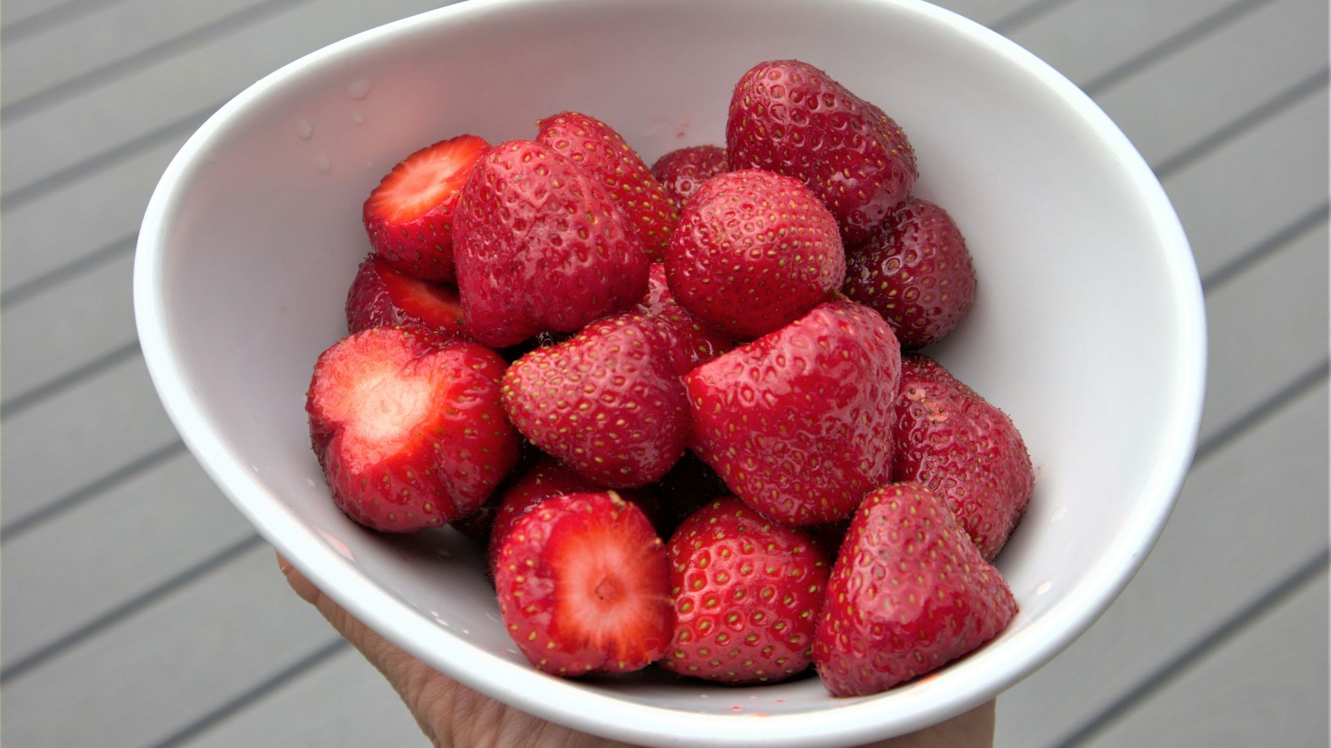 red strawberries in white ceramic bowl