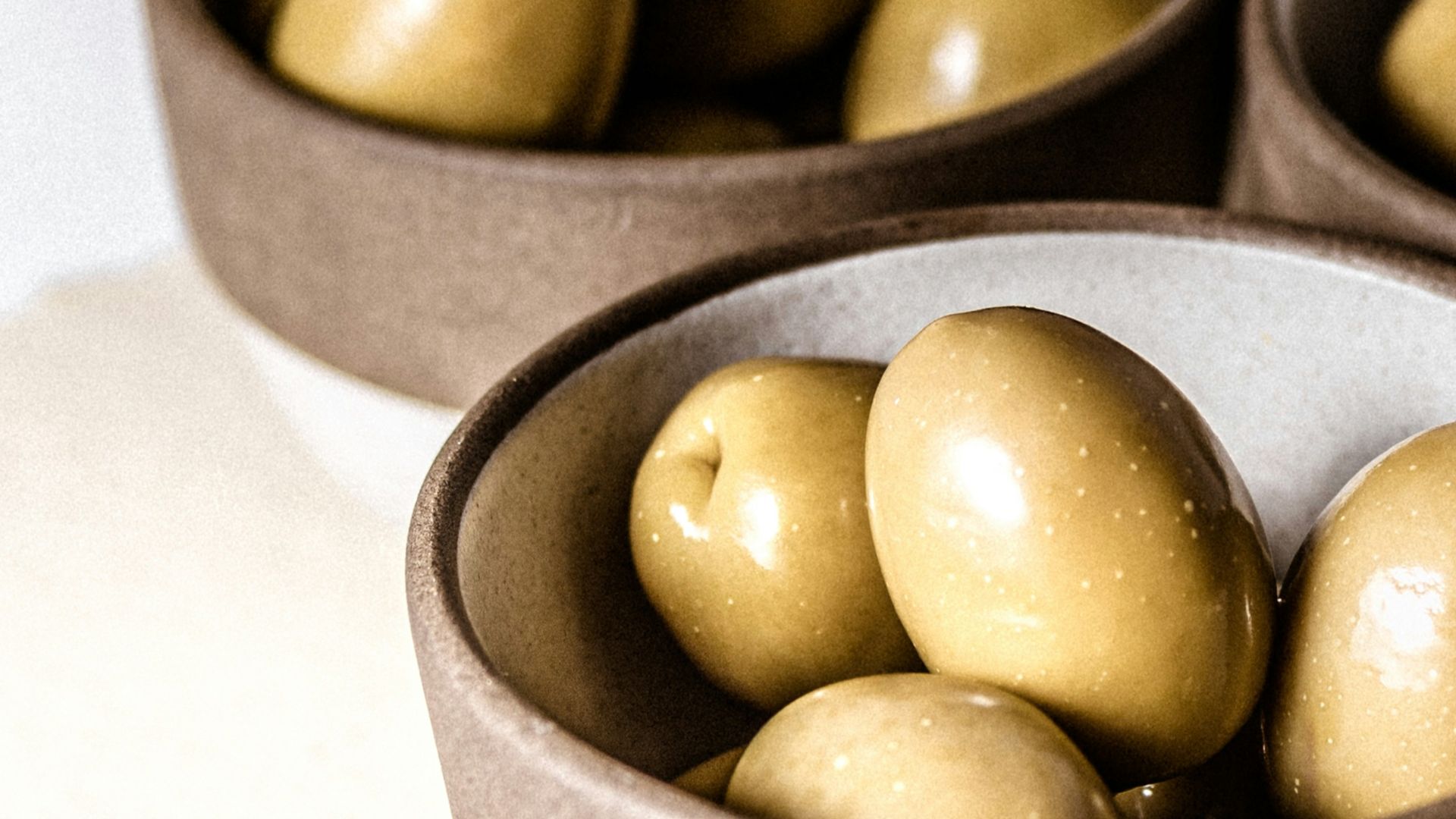 green round fruits on black ceramic bowl