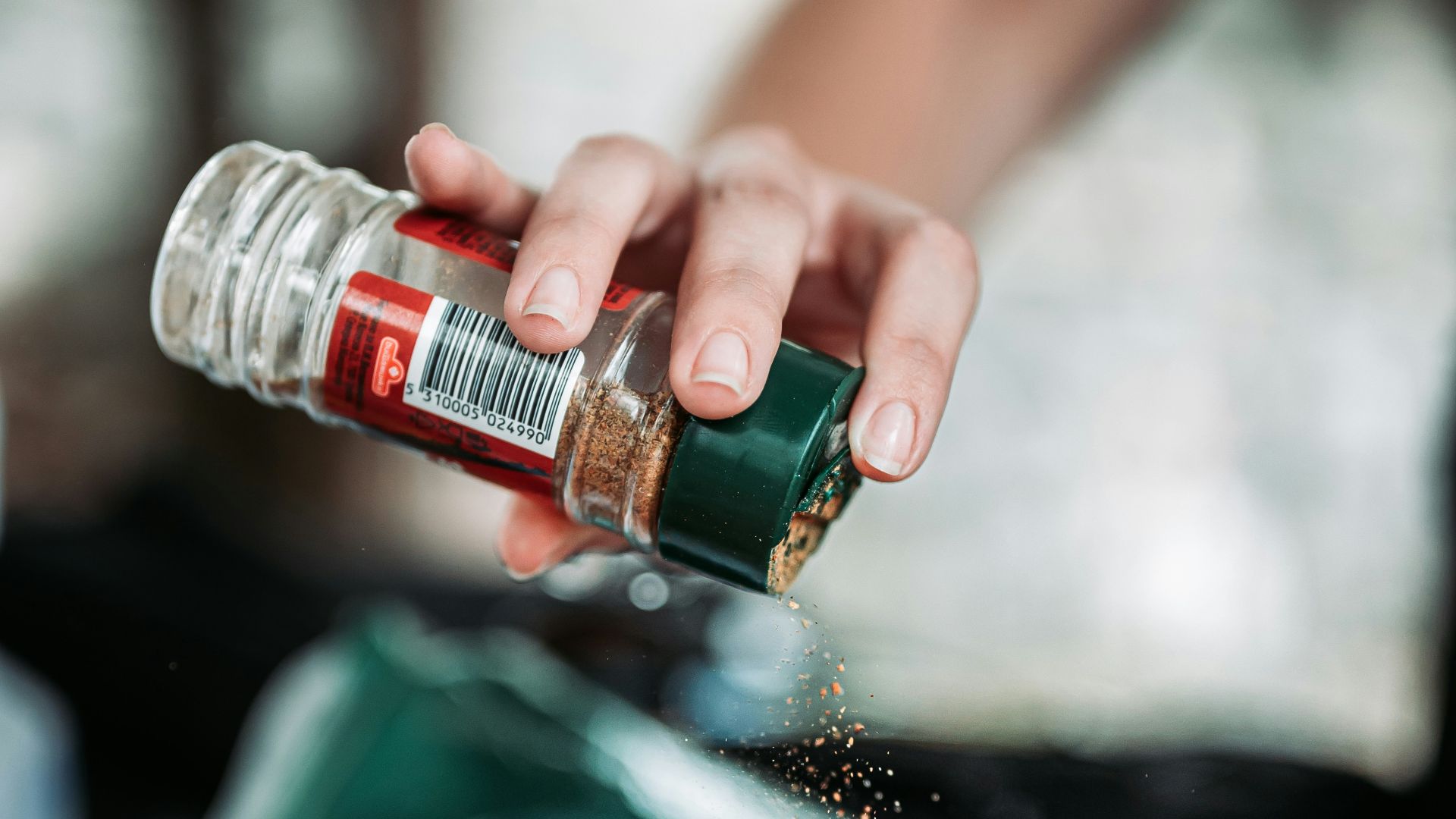 person holding green and red bottle