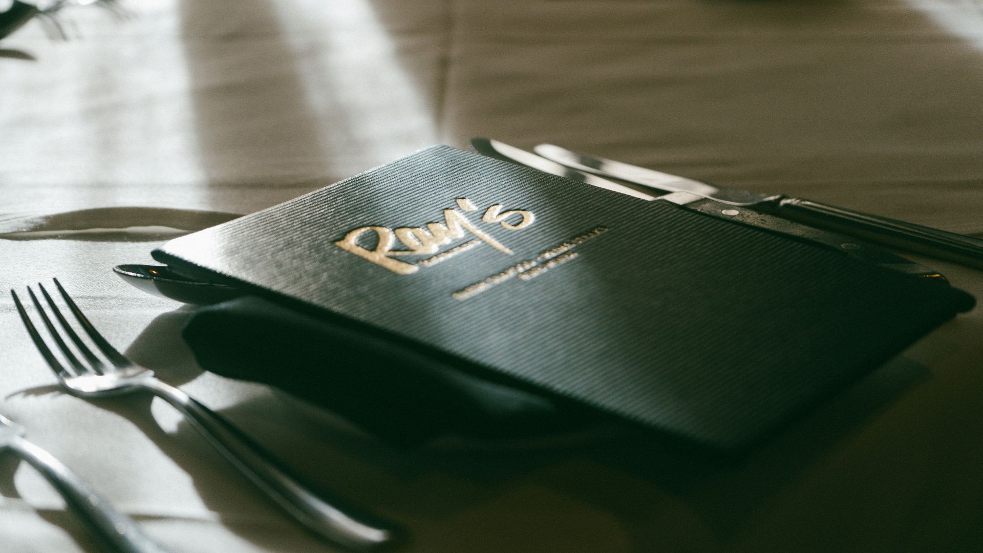 A table with a menu and silverware on it