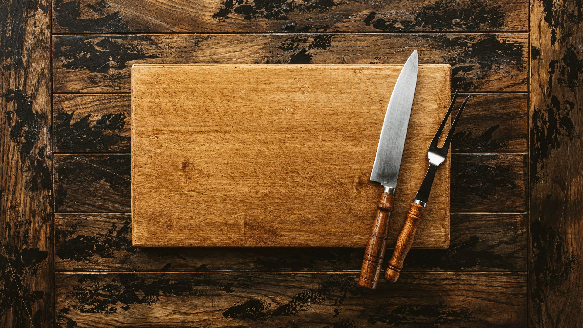 a knife and a board on a wooden surface