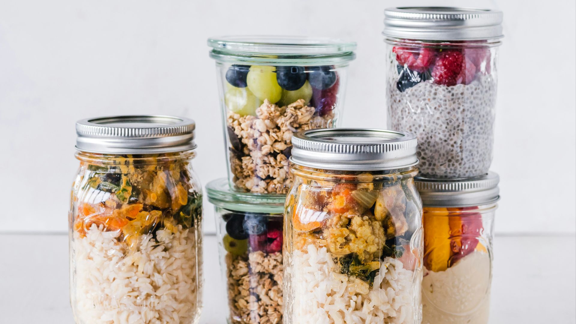 six full clear glass jars on white surface