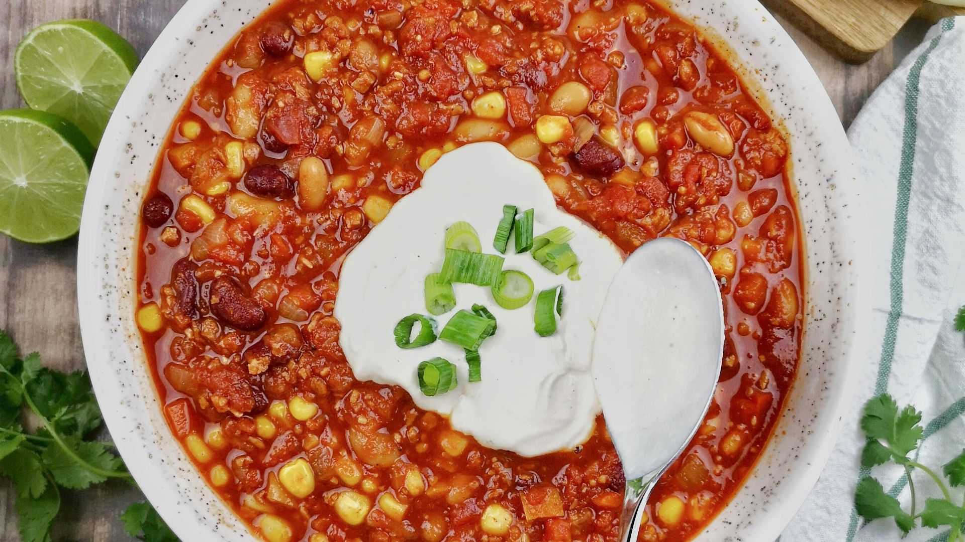 a bowl of chili with sour cream on top