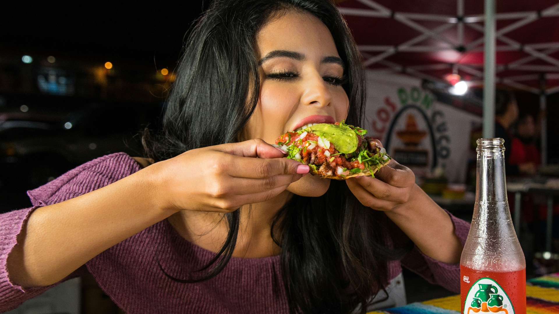 woman in purple shirt holding green and yellow floral ceramic bowl