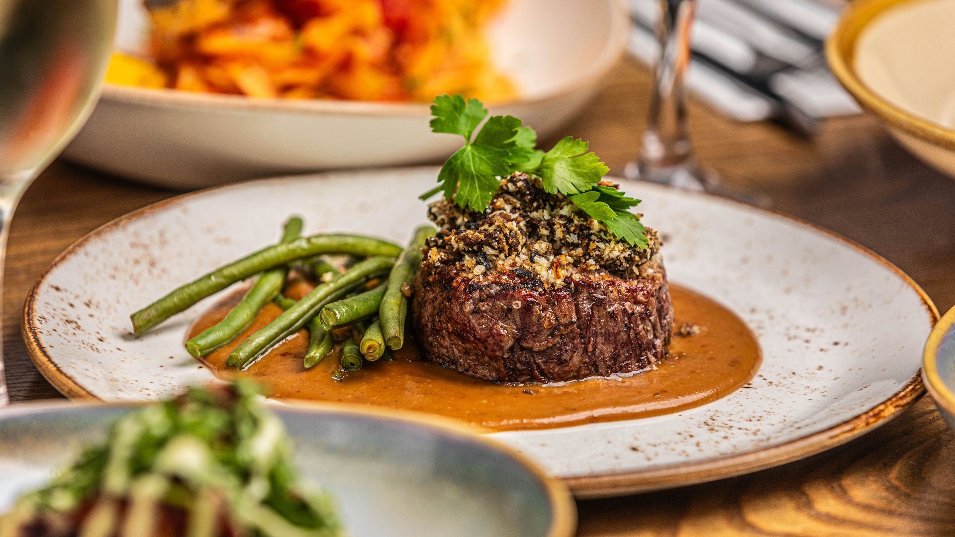 a plate of food on a table with a glass of wine