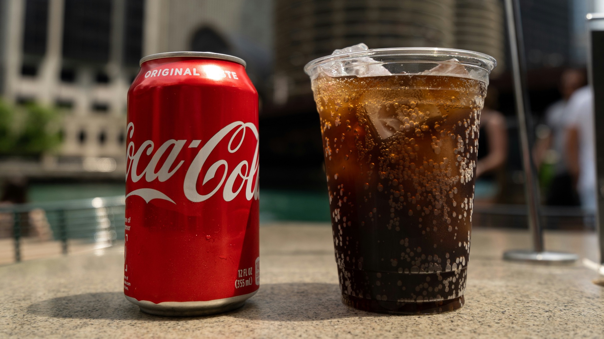 Coca-Cola soda tin can and cup on table close-up photography