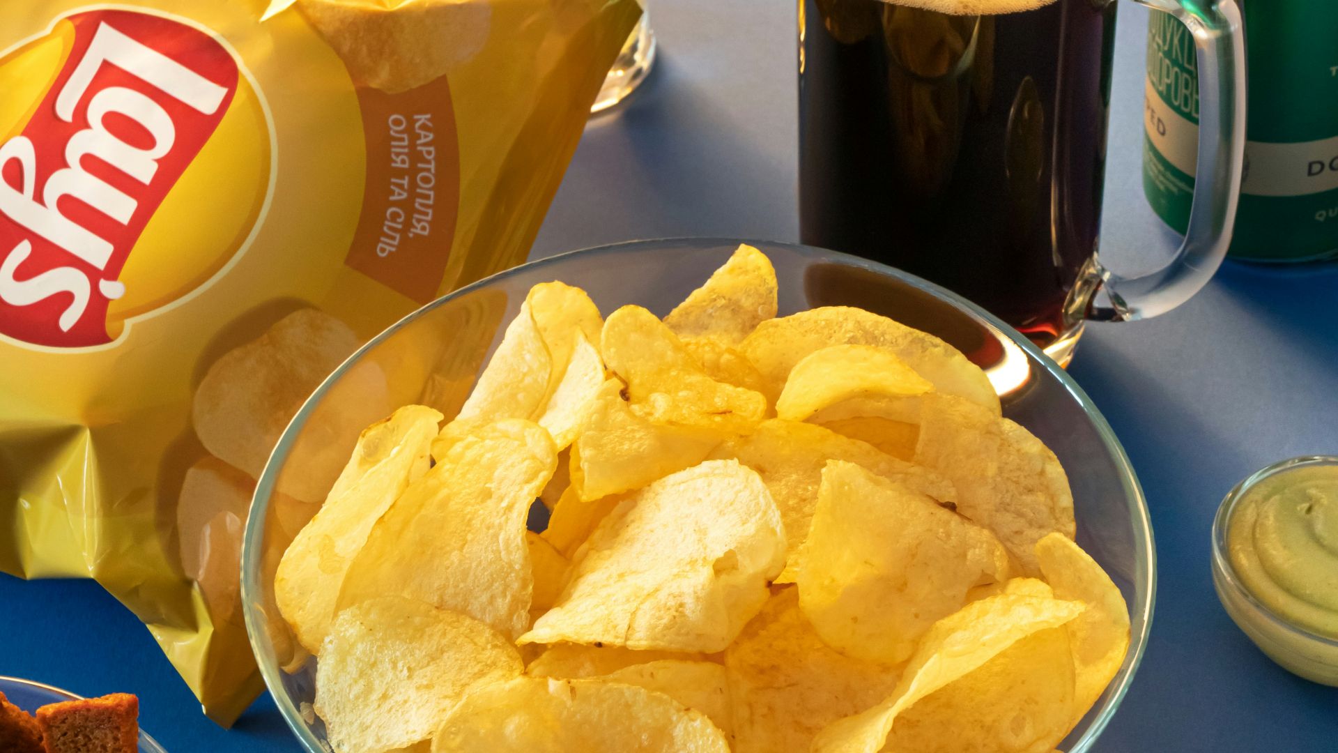 clear drinking glass beside brown bread on blue ceramic plate