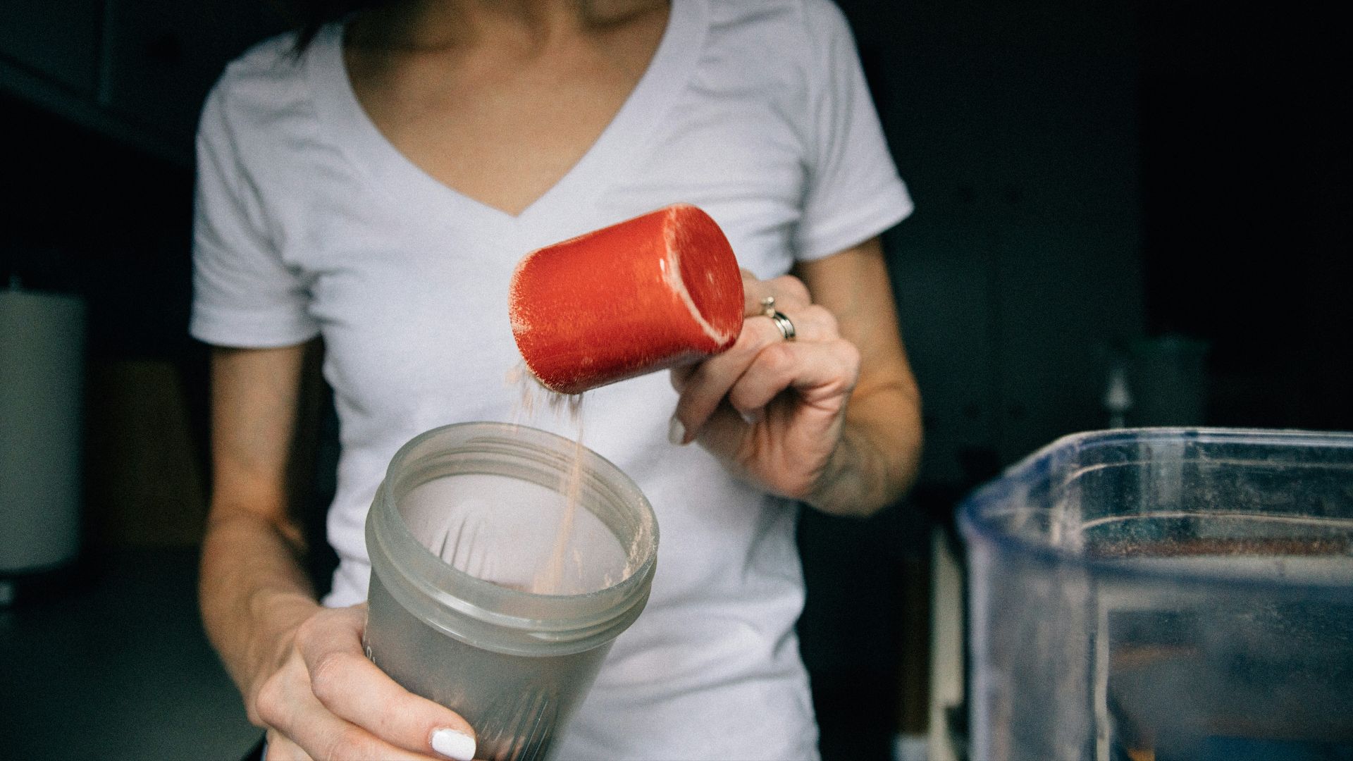 woman in white crew neck t-shirt holding red plastic cup