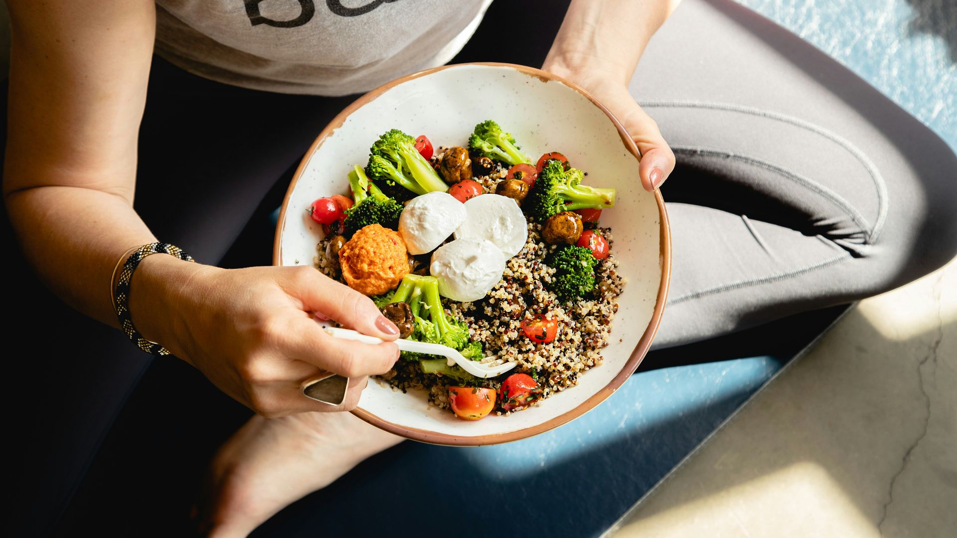 a woman is holding a bowl of food