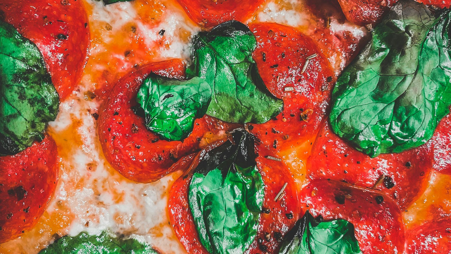 a close up of a pizza with tomatoes and basil