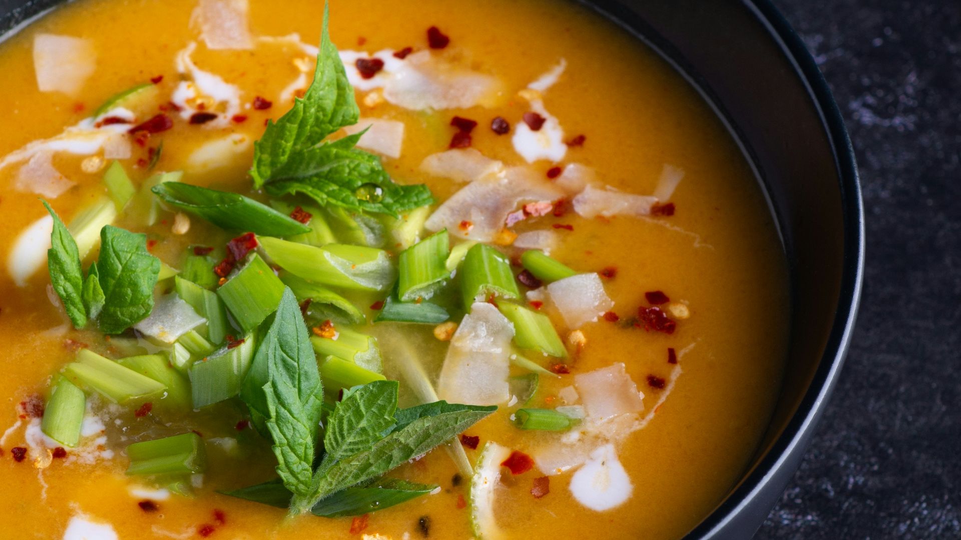 soup with green leaf on black ceramic bowl