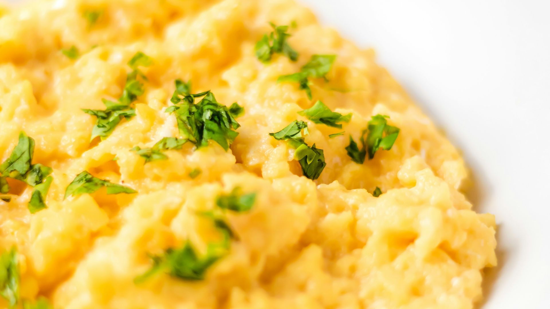 a bowl of mashed potatoes with parsley on top